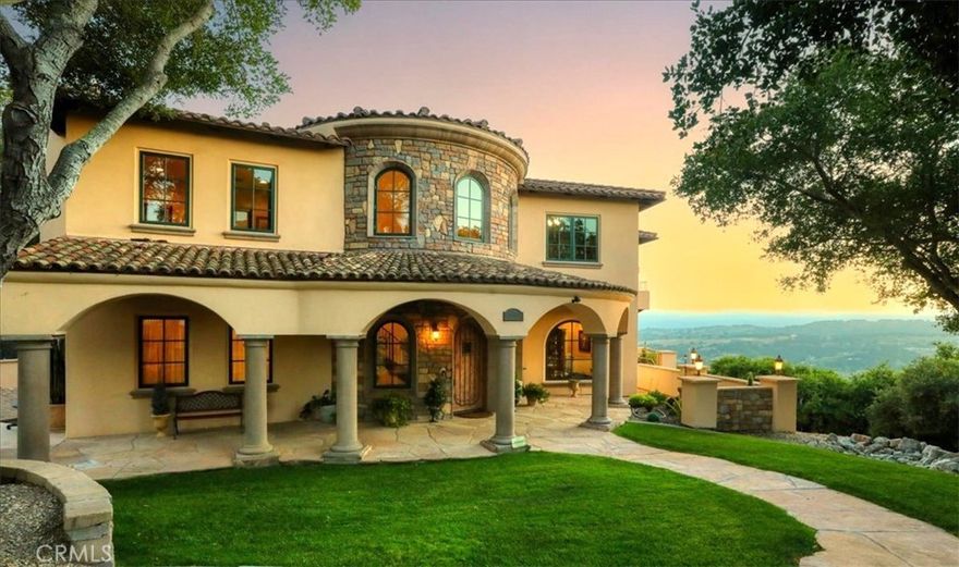 Enjoy the elegance and serenity of this magnificent Tuscan inspired villa that creates a sophisticated yet relaxing atmosphere. Absolutely incredible panoramic views stretch to the Pacific Ocean, the Edna Valley and beyond to the peaks of San Luis Obispo. Entering the home, you will find a welcoming foyer with elevated beam ceiling and beautiful custom wood and iron staircase. The versatile and thoughtfully designed floorplan includes elegant engineered wood flooring throughout the main level and natural wood beamed ceilings. Five fireplaces throughout create an intimate atmosphere. Numerous Jeld–Wen windows provide abundant natural light and outdoor views. On the main level a gourmet kitchen features beautiful natural wood cabinetry with convenient sliding pull out drawers in each cabinet, a Wolf cooktop with custom hand-crafted vent hood, built-in refrigerator, wine fridge, spacious granite counters, and more. The adjoining great room with wood burning fireplace offers access from both sides to outdoor spaces making it ideal for entertaining. On one side, picturesque vistas of the valley, vineyards and ocean await you from the view deck that is over 50’ in length. While on the other side is a protected courtyard with its own fireplace creating a relaxed ambiance to enjoy more views and sunsets. In addition to these amazing outdoor spaces is another courtyard at the southside of the residence that is a perfect place for morning coffee or breakfast as the sun rises above the oak trees. The owner’s suite with its elevated ceiling, fireplace and view deck is a tranquil place to start and end your day. The en-suite bathroom has a separate tub, walk in closet and spacious step-in shower with its own valley and ocean views. There are also two additional guest suites that include their own bathrooms, one with it's own view deck. There is a library, a gym and an office, each with the potential for many other uses or could be converted to additional bedrooms. There is an abundance of storage closets throughout, including two intentionally placed for a future elevator if needed. On the lower level is a 500 sq ft guest studio complete with kitchenette, a full bath, private access and private view deck. There is also a hobby room near the oversized 3 car garage. Surrounded by over 4,500 acres of protected open space, Las Ventanas Ranch is a highly sought after, exclusive custom home community just a few minutes from the Village of Arroyo Grande and San Luis Obispo.