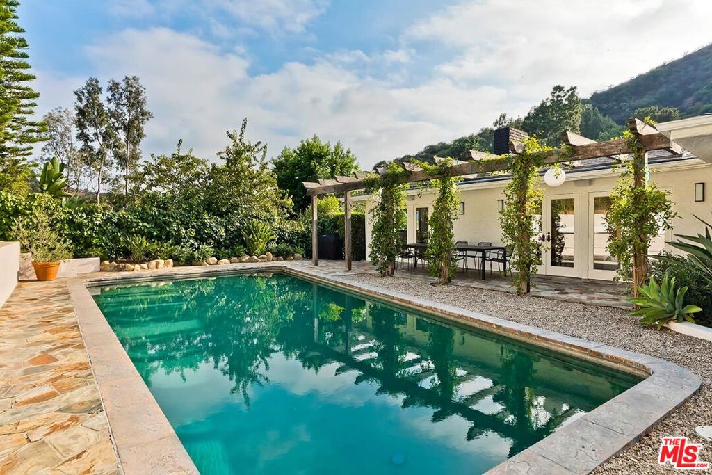 Wonderful resort-like Contemporary home with sensational pool and yard. Enter through a gated court yard to a light and bright living room featuring a wood burning fireplace, hardwood floors and walls of glass. Remodeled open kitchen with large island perfect for entertaining and eat-in dining area. Private primary suite bath and dual closets. There are 3 additional bedrooms, one currently used as a media room and another as a home office. Large glamours outdoors with trellis, marvelous for al fresco dining overlooking the oversized pool and lounge areas. Convenient location minutes to the heart of Beverly Hills or the Valley on a lovely cul de sac street. 2 car garage. A true haven.