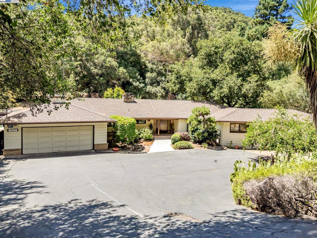 Discover the perfect blend of tranquility and convenience in this sprawling single-level home, tucked away in the serene beauty of Palomares Canyon—just minutes from Bay Area amenities. Relax on the welcoming front porch and enjoy the sights and sounds of nature all around you. The rustic family room features open beam vaulted ceilings, a striking stone fireplace, and a wall of windows framing views of the deck, pool, trees, and nature. The kitchen offers wood flooring, tile countertops, a double oven, built-in microwave, pantry, and generous counter space—ideal for cooking and entertaining. The spacious primary suite overlooks the creek and boasts a huge walk-in closet and a large private bath with double sinks and a stall shower with two showerheads. Additional highlights include ample closet and storage space, a separate laundry room with half bath, and a .7-acre lot—big enough to spread out without overwhelming upkeep. Outside, enjoy an in-ground pool, fruit trees, a detached shop, dog kennel, carport, and private well with a 2,500-gallon water tank. The home is in original condition, offering a wonderful opportunity to customize and make it your own. Your perfect slice of heaven in the Bay Area awaits!