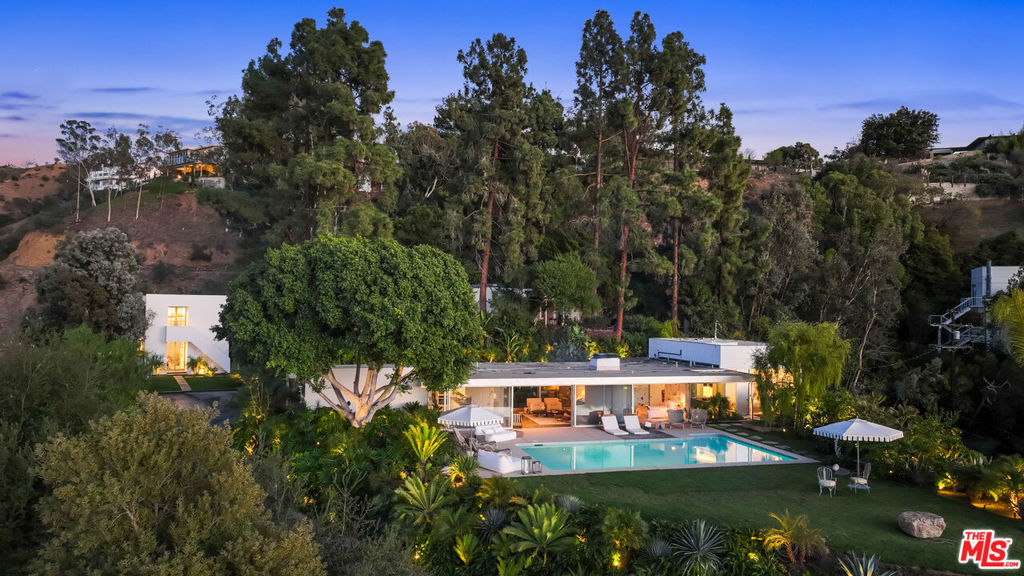 Originally built in 1958 by celebrated modernist architect, Richard Neutra, The Loring House is a captivating compound in the Hollywood Hills; soaking in panoramic views of the canyons. This showpiece property is a part of California's rich architectural legacy, with rooms forming the modular midcentury layout famously recognized throughout the Neutra collection. Design duo, Escher GuneWardena, extended the grounds with a glass-paned master suite and bath. The living room features a built-in fireplace and oversized glass windows, allowing the scenery to spill over from the private patio and cinematic pool deck. Natural light bathes the kitchen and dining area, and extends onward to a detached guesthouse, designed by Steven Ehrlich, FAIA. Complete with a kitchen, lofted quarters and ample studio space, the suite flaunts stunning views through greenhouse style windows. Just minutes from Sunset Blvd, The Loring House pairs couture design and practical comfort for ultimate experience in luxury living.