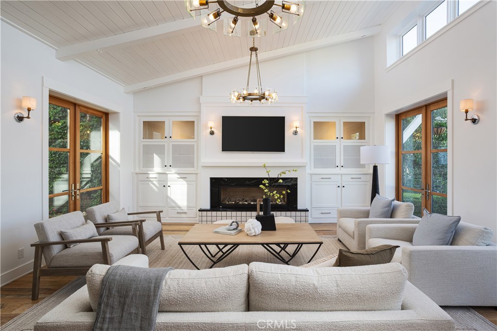 Welcome to 2217 Laurel Place —a bespoke architectural gem tucked away on a quiet cul-de-sac in coveted Newport Heights. Inspired by the clean lines and warmth of a Swedish coastal retreat, this one-of-a-kind home (“Hem” in Swedish) was designed to honor the natural elements. Built thoughtfully with sustainable, zero waste construction and careful selections throughout, the striking vertical lines, a bold asymmetrical roof, and clerestory windows form a sculptural silhouette dramatic yet harmonious flooding interiors with natural light while celebrating the outdoor spaces. Inside, the vaulted living room makes a statement with tongue-and-groove ceilings, exposed beams, and a central fireplace flanked by inset French doors. Reclaimed wood floors flow through to the dedicated dining space, chef’s kitchen and wrap-around bar all connected by oversized sliding glass pocket doors opening onto the lush, inviting yard. The kitchen is a study of form and function featuring natural soapstone countertops, Wolf range, Sub-Zero refrigerator, dual farmhouse sinks, walk-in pantry, and a custom, hand-sourced light fixture. Outside, the mature trees and garden provide a beautiful private backdrop for enjoying the perfect Newport Beach climate. The covered patio with built-in BBQ and adjacent fire pit area creates a setting perfect for gathering, lounging and celebrating under the stars. Upstairs, two bedrooms (one with a balcony) feature walk-in closets and a Jack-and-Jill bath, while a third bedroom enjoys a private en-suite. A cozy loft nook provides space for reading or play. The primary suite is a serene retreat with oversized windows framing treetop views, a massive walk-in closet, and a freshly redone spa-style bath wrapped in calacatta gold marble tile complete with a luxurious shower and freestanding soaking tub.A versatile detached casita sits at the corner of the property, complete with vaulted ceilings, floor-to-ceiling windows, and a full bath; ideal for a guest suite, home office, gym, teen lounge, or creative studio. Dual access from Holly Lane and Laurel Place gives the home two distinct fronts and easier passage to both Irvine Ave & Tustin Ave.The back gate on Holly Lane that leads to the casita and private yard masquerades as a front door while the oversized garage offers space for vehicles, a gym, workbench, and storage. 2217 Laurel Place isn’t just a home — it’s a “Hem” and conscious choice in design and lifestyle.