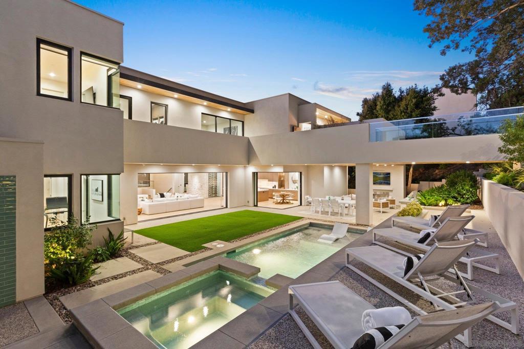 Exquisite modern contemporary set on nearly one-half acre in the prestigious Muirlands Estates. Expertly crafted for lux livability and functionality, the home is awash in natural light and stylish design. Culinary enthusiasts will relish the 5-star kitchen with its Wolf gas cooktop, induction Teppanyaki burners, and over-sized marble-topped island with built-in butcher block. Entertainers will welcome the glass walled wine room, private dining room, bar and butler’s pantry. A great room features 10’ coved ceilings and a limestone fireplace surround. The outdoor courtyard seamlessly flows from interior spaces and includes a pool, spa, BBQ area, clear cedar ceilings, fireplace, tv and more. An exceptional primary bedroom retreat offers his and hers spaces, heated floors, and a private courtyard with gas firepit and living wall. Incredible extras include a separate 400-sf casita, gym, gallery art hall, media room, and executive office.