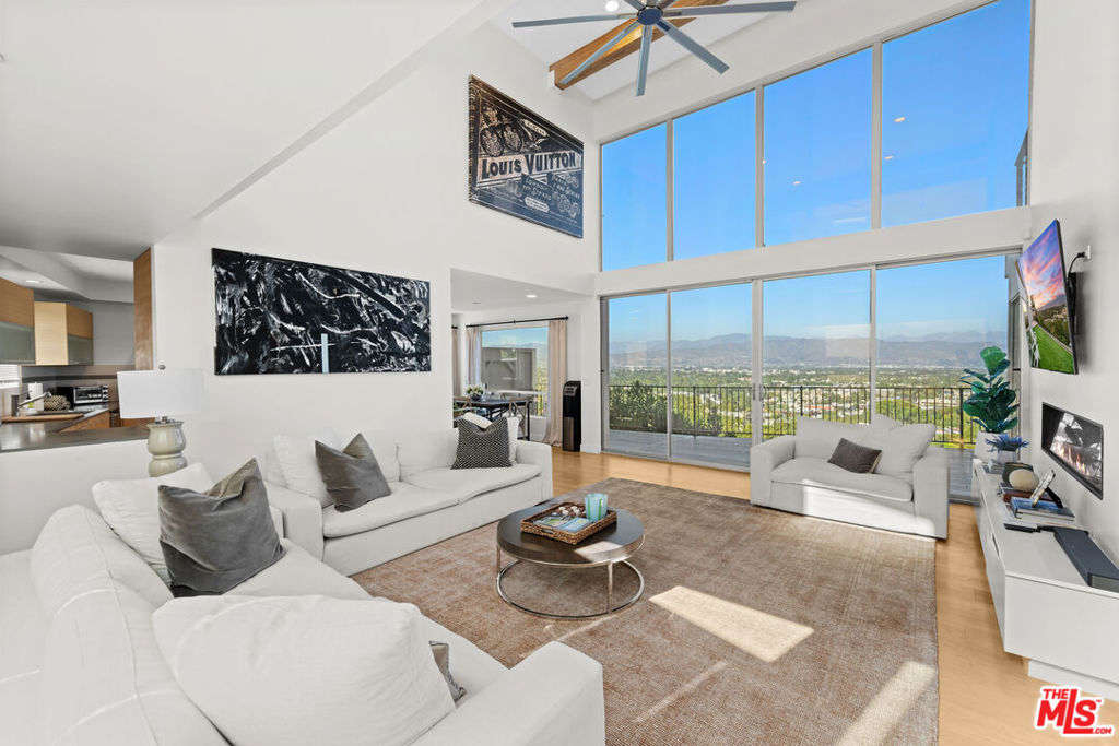 Welcome to this stunning Jon Brouse AIA designed modern residence South of Ventura Boulevard perched above Studio City's Silver Triangle with showstopping panoramic city-light sunrise sunset views. This one-of-a-kind 2 story residence with ADU boasts 5 bedrooms 5 baths and 2800 square feet masterfully framed with soaring 18ft ceilings, expansive walls of glass and effortless indoor-outdoor living to multiple large viewing decks and backyard. The main 2200 square foot residence centers around a picture perfect 2-story dramatic gallery inspired Great Room fabulous for art with full wall of glass and linear fireplace. The chef-inspired designer kitchen is perfect for everyday living and elevated entertaining boasts quartz counter tops, high end appliances, center-island seating open to the dining area with additional corner window to devour the views. A main floor ensuite bedroom & additional downstairs bedroom and bath makes this floorplan ideal offering 2 bedrooms up, 2 down. Upstairs divided by a suspended walkway both en-suite bedrooms are strategically positioned to deliver mesmerizing sights of a glorious sunrise or the glistening city lights. The primary includes a massive private balcony to soak it all in, custom-fitted walk-in and gorgeous bath with loads of glass luring warm natural light with dual vanity. A separate 600 square foot 1 bedroom 1 bathroom ADU has its own washer, dryer and private viewing deck that captures the same sweeping views as the main house; ideal for guests, music studio, or income potential. This is truly a one of a kind architectural gem not to be missed!