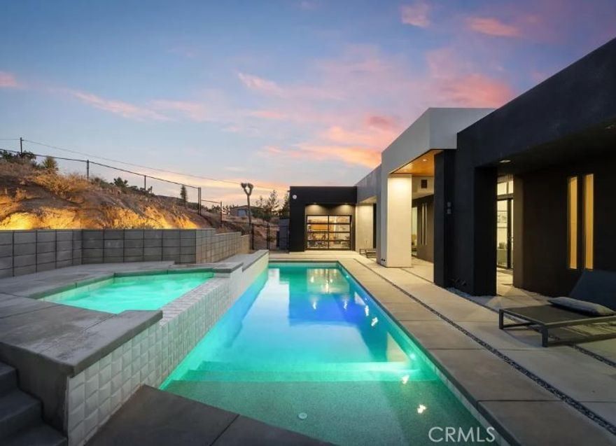 KING OF THE MOUNTAIN! Come and see this stunning modern retreat in Yucca Valley.

Discover this exceptional 21-acre property, a true oasis that combines luxury and comfort in the heart of the desert. Spanning an impressive 2,089 square feet, this modern build boasts three spacious bedrooms and three beautifully appointed baths, making it ideal for families or anyone seeking a serene getaway.

Step inside to find high ceilings that create an airy ambiance throughout the open kitchen and living areas. The kitchen is designed for both functionality and style, perfect for entertaining or enjoying quiet evenings at home. Cozy up by the fireplace in the living room, providing warmth and a touch of elegance during cooler desert nights.

For fitness enthusiasts, the expansive garage includes a dedicated gym space, allowing you to maintain your workout routine without ever leaving the property. The three-car garage offers ample storage and convenience.

Outside, indulge in your private in-ground pool and spa, perfect for cooling off during hot summer days or unwinding under the stars; surrounded by privacy fencing perched on top of a mountain. The stunning mountain views and unique desert landscape enhance the already picturesque setting, providing a truly tranquil experience.

This property is not just a home; it’s a very successful vacation rental, making it a fantastic investment opportunity. Whether you're looking to escape to the desert or seeking a profitable venture, this Yucca Valley gem has it all.