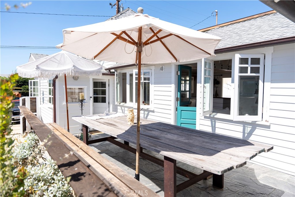 Nestled in the heart of Woods Cove, this beautifully renovated historic ocean-view beach cottage captures the essence of California coastal living and once served as the home of Laguna’s famed Greeter, Eiler Larson. Beyond the gated entry, an inviting outdoor sanctuary awaits with thoughtfully designed drought-tolerant landscaping and a spacious patio with seating for 12, all set against panoramic views of Catalina Island. Inside, distinctive designer touches elevate every corner of this move-in-ready retreat, featuring 3 bedrooms and 2 baths. The gourmet kitchen is equipped with premium stainless steel appliances and a striking Brazilian rosewood peninsula—perfect for gathering, entertaining, or watching TV—flowing seamlessly into a light-filled living room with white beamed ceilings and an original brick wood-burning fireplace.The generous primary suite offers custom built-in closets, drawers, and shelving, seagrass carpeting, and a luxurious bathroom with a soaking tub. A cozy den with a Scandinavian-style built-in sofa provides an ideal secondary lounge for movie nights or game time. The third bedroom, an upstairs loft accessed via a functional ladder, enjoys refreshing sea breezes and a private perch for whale watching. Outdoors, a shaded entertainment area includes a gas grill, ping pong table, kegerator, vegetable garden, Tesla/EV charger, laundry area, and driveway parking for two. Perfectly situated just moments from Laguna’s most picturesque beaches, acclaimed restaurants, galleries, boutique shopping, trolley access, and more, this stylish haven blends historic charm with modern comfort.
