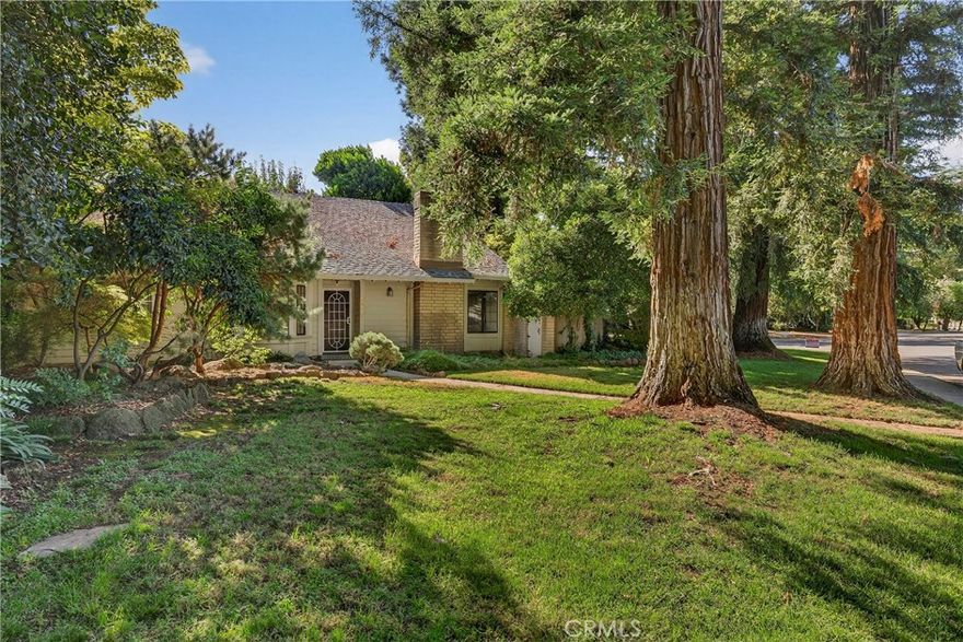 Welcome to 2413 Holly Avenue, a stylish home nestled in a desirable neighborhood in North Chico. This 3-bedroom, 3-bathroom 1764 sq.ft. home blends distinctive charm with thoughtfully designed living spaces, and a floor plan to meet all of your needs. Surrounded by mature redwoods and beautifully landscaped grounds, this home offers a peaceful retreat that feels secluded, yet remains central to all of Chico's amenities. The main level includes a bright and open living room with soaring, exposed wood beam ceilings, a stunning fireplace, tile flooring and a formal dining area separated by a tasteful glass-block wall, providing the perfect space for entertaining or enjoying quiet evenings at home. The kitchen offers chic tile flooring, granite countertops, a garden box window and ample cabinet space including a built-in wine rack. The private ground level primary suite offers two walk-in closets, an updated ensuite bathroom with separate sinks and vanity areas, updated granite countertops and a walk-in shower. The main level also includes a second bathroom and bedroom including built-ins and a slider with private patio access. Upstairs is a bright open loft space that can be used as an office or additional living space. Adjacent to the loft is a generously sized guest bedroom and full bathroom, offering a floor-plan for everyone to have their own space. Additional features include an attached two car garage, use of common areas in a planned development that pays for water, trash and landscaping with a low monthly HOA payment of $350...an incredible value considering what monthly water, trash and landscaping bills add up to! Septic and roof certifications on file. Make an appointment today to see this charming and lovely home in person!