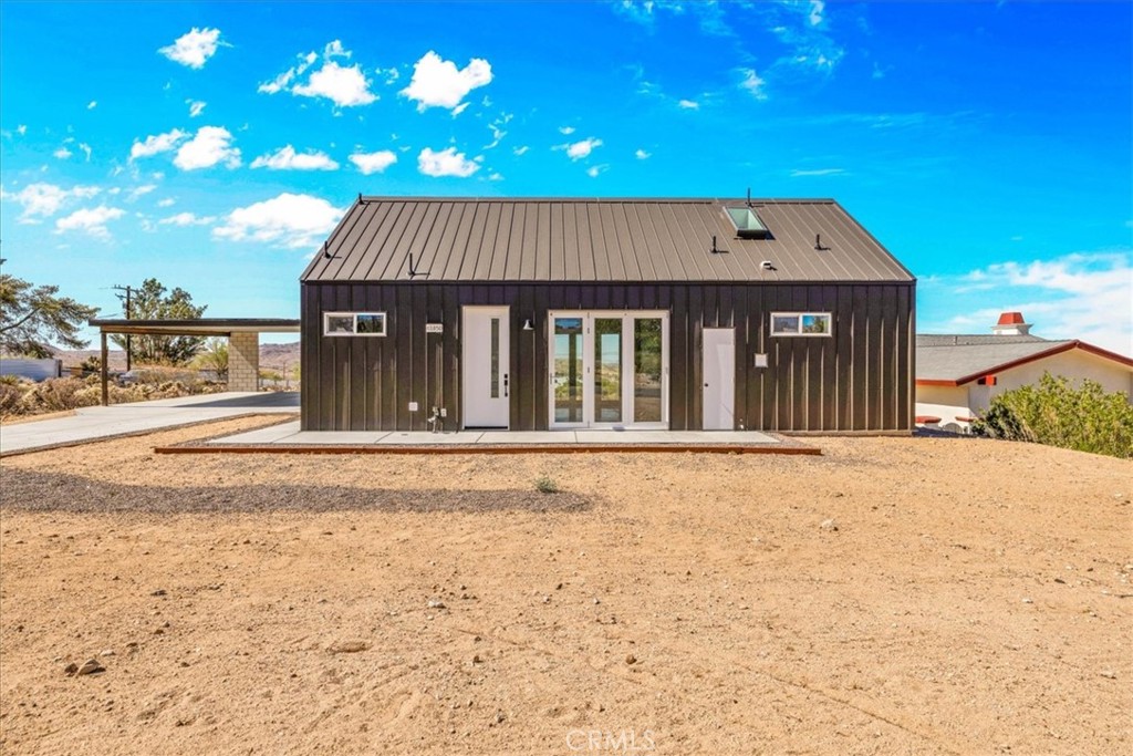Tucked into the heart of Joshua Tree Village, this thoughtfully designed 2-bedroom, 2-bath barn-style home blends modern architecture with desert charm. Offering 800 square feet of interior living space with a 97 square foot loft, and a 400 square foot carport, the home is both functional and aesthetically striking. Expansive windows and sliding glass doors flood the open-concept interior with natural light, while polished concrete floors and sleek finishes create a refined, contemporary feel.
The kitchen is appointed with stainless steel appliances and offers a clean, stylish space ideal for those who enjoy cooking or entertaining. The primary bath includes a spacious walk-in shower, dual sinks, and an oversized vanity that balances comfort and design. The loft adds flexibility, perfect for a creative workspace or additional lounging area. Efficient minisplit systems provide year-round climate control.
Located just moments from local galleries, coffee shops, and eclectic boutiques, this home offers a peaceful retreat with convenient access to Joshua Tree National Park, the farmers market, and cultural events like the Joshua Tree Music Festival and Art Walk. With its distinctive character and connection to the landscape, this home presents a rare opportunity to live in one of California’s most iconic desert communities.