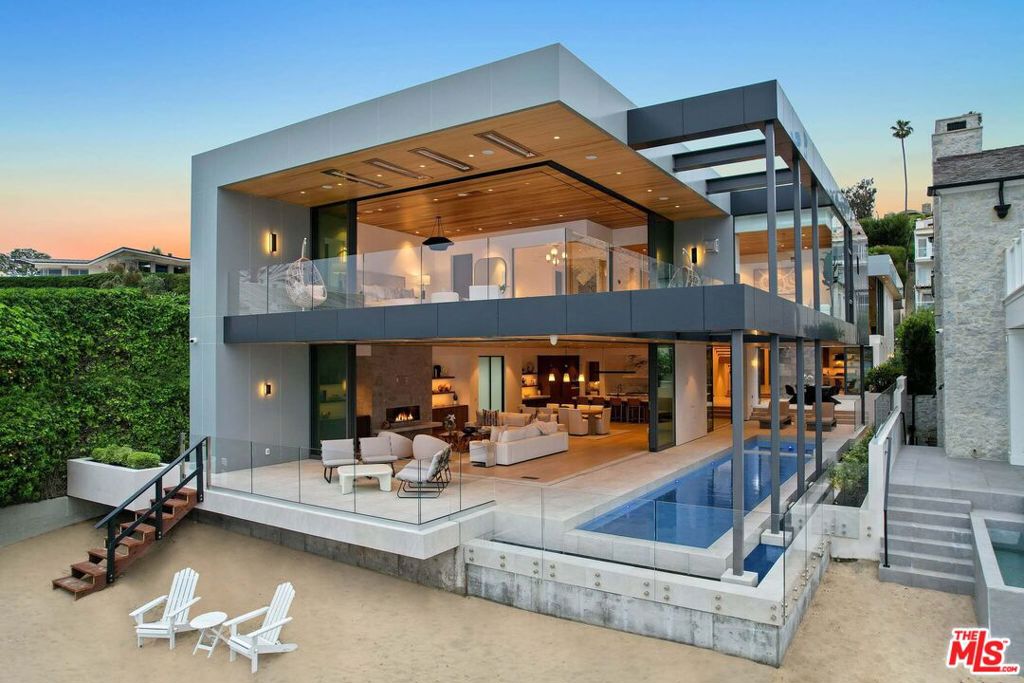 This newly constructed custom estate offers exclusive Corona Del Mar waterfront living with intricate design touches and a harmonious blend of natural stone and wood elements. Consisting of 5 ensuite bedrooms and 9 bathrooms and boasting approximately 50 feet of private beachfront, it caters to water enthusiasts and offers shared ownership of one of the longest private docks on the west coast, capable of accommodating multiple yachts up to 100ft in length. Upon arrival, you will be greeted by meticulously landscaped surroundings, a striking grand pivot door, and a double height foyer that sets the tone for the residence. Inside, the space boasts European wide plank bleached oak flooring by Gaetano, illuminated floating staircases, and expansive glass features that fill the approximately 9,129 square feet of interiors with an abundance of natural light. The property seamlessly connects to its surroundings through slide-away pocket doors that open onto a heated patio, a zero-edge saltwater pool and spa, and a courtyard featuring a built-in Lynx Grill. The kitchen features custom Honed Calcatta Vagli slab countertops and backsplash, a 55" La Canche designer stove imported from Paris, a butler's pantry, and stained white oak cabinetry. Convenience is paramount, with a Waupaca elevator servicing all four floors, including the lower level, which encompasses a media area, a dry bar, and temperature controlled wine room. Upstairs, the owner's suite presents a heated wraparound balcony with mesmerizing water views, a living space with a fireplace, and two spa-like bathrooms, each complemented by its own walk-in closet. The top level reveals a lounge area that opens onto a rooftop deck with grass and sweeping views of the Newport Beach Harbor offering limitless ocean-view entertaining. Equipped with cutting-edge technology, the property also includes a nearly 3,000 sq. ft., 6+ car garage with epoxy flooring. Expertly designed by Brandon Architects, Patterson Custom Homes, Harvard Investment Group, and Brooke Wagner Design.