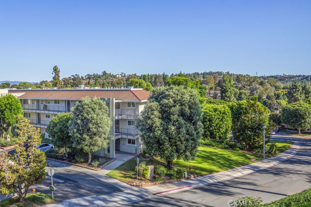 Welcome to 3338-1G Punta Alta – a two-bedroom, two-bath, ground floor end-unit ARAGON residence in the Laguna Woods senior community. This home has been tastefully upgraded to create a charming and inviting living environment. Being an end unit allows for one less common wall and an additional window in the living room. Situated centrally in the “Village”, this residence is far from busy roads and noisy highways. The kitchen has been fully remodeled with the original wall separating the kitchen from the living room replaced by an island that has seating for 2-3 and supplemental cabinet storage. Additional kitchen features include granite countertops, stainless steel appliances, soft-close cabinet doors and drawers and a pots and pans drawer with convenient pull-out shelving. Bonus features throughout include smooth ceilings and dual-pane windows. The rear patio is accessible from the living room via a glass slider and is the ideal location for outdoor entertaining, dining and relaxing. Built-in planters on either side of the patio are a nice added touch. The patio boasts a lovely panoramic view of endless trees stretching into the distance. The primary bedroom shares this gorgeous view through large windows. The assigned carport is close by and offers additional cabinet storage. Do not miss this beautiful home!