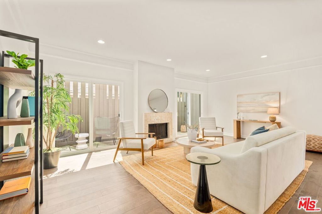 Spacious and bright 2BR+2.5BA townhouse located in the heart of Santa Monica. Newly installed wood floors on the 1st floor showcase the large living area with decorative fireplace, recessed lighting and new glass sliding doors overlooking the patio spanning the width of the unit. Eat-in kitchen has stainless steel appliances, with ample cabinet space and custom cabinets, that leads out to the spacious dining area. The powder room and coat closet complete the first-floor. The second-floor features two en-suite bedrooms including the large primary with high ceilings, walk-in closet and private balcony. Side-by-side laundry room with full-size washer and dryer. Both bedrooms have no common walls. Kinetico water filtration system. Two side-by-side parking spaces with storage unit in gated garage. Boutique 5-unit building that includes earthquake insurance. Would make a wonderful place to call home.