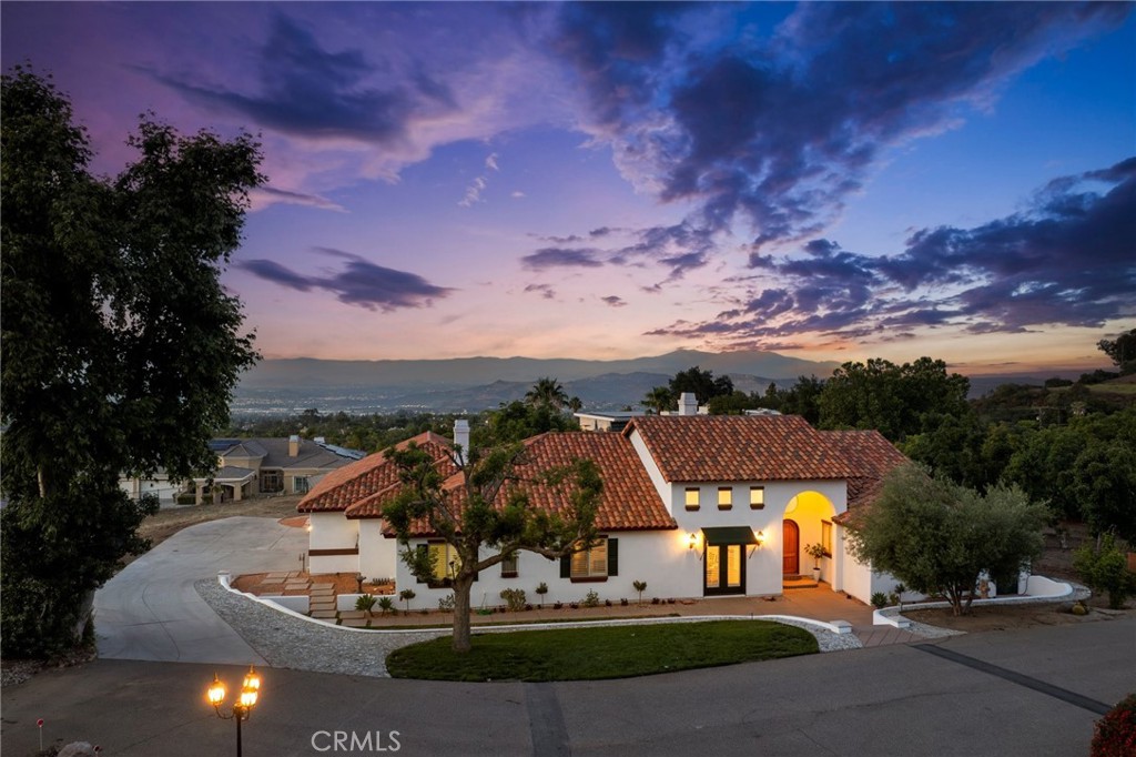 Turnkey Luxury Estate on 1.07 Acres – Tucked behind a private gate on a quiet road shared with just three other custom estates, this stunning turnkey single-story home offers the ideal blend of luxury, privacy, and outdoor living. This breathtaking property in South Corona has 360 panoramic views of the city lights and Cleveland National Forest and provides rare access to miles of hiking and biking trails, breathtaking views, and a peaceful, nature-filled lifestyle.
Set on 1.07 acres of flat, fully usable land, this custom 4-bedroom, 3-bathroom estate spans 3,211 sq ft (approx. 4,200 sq ft including the 4-car garage) and boasts over $200,000 in recent upgrades.
Interior Highlights:
-Chef’s kitchen with all-new Viking appliances and custom wood cabinetry
-Soaring ceilings: 16’ in the entry/living room and 10’ throughout the home
-Designer finishes: 8-ft doors, dual-pane windows, high-end Kohler fixtures
-Spa-inspired bathrooms with marble, quartz, and limestone countertops
-Modern systems: Dual-zone HVAC, central vacuum, newer water heater (2024), alarm system, and copper plumbing
-Plenty of storage throughout the home for seamless organization
Outdoor Living at Its Best:
-Private pool and fire pit for resort-style relaxation
-All-new outdoor kitchen and bar tops ideal for entertaining under the stars
-Producing avocado grove with 40+ mature trees
-Additional fruit trees, including citrus and macadamia
-Expansive, flat grounds with endless possibilities for outdoor enjoyment
Additional Features:
-Newly upgraded Vulcan fireproof attic vents and full fire sprinkler system
-Ring camera system and alarm for peace of mind
-Durable stucco exterior and timeless Spanish clay tile roof
-All major systems recently updated, including HVAC, pool heater, plumbing, and more
Located within the top-rated Corona-Norco Unified School District—zoned for Santiago High, Citrus Hills Intermediate, and Eisenhower Elementary—this one-of-a-kind estate offers luxurious living, total privacy, and direct access to nature, all just minutes from shopping, dining, and freeway access.