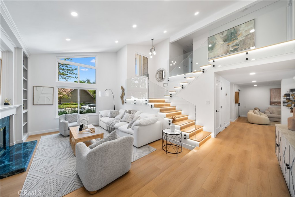 A rare, fully reimagined designer home in Orange County—truly turnkey and custom rebuilt to perfection. Located in the prestigious Montbury on the Hill community in North Lake Forest, this stunning residence was transformed by a Newport Beach-based professional designer focused on luxury, functionality, and signature style. For buyers tired of cookie-cutter tract homes, this is a custom alternative that stands out in every way. Among its most exceptional features are dual primary suites—one on each level—ideal for multigenerational living, guest flexibility, or a dedicated office. Natural light floods the home through soaring ceilings and expansive windows, creating a warm, open, and elevated atmosphere. The chef’s kitchen features GE Café appliances, Taj Mahal quartz countertops, custom cabinetry, and integrated LED light strips that extend into the closets and staircase—every inch thoughtfully crafted. A spacious family room offers a custom media wall, built-ins, and an open lounge with a transparent glass wine display. The downstairs suite includes sliding-door access to the backyard, a spa-style bath with a freestanding tub, dual rain-head shower, double vanities, and a large walk-in closet that can double as a dressing room or office. Upstairs, a second primary suite offers a fireplace, full bath, and large sitting area. Two additional bedrooms feature custom closets and share a dual-sink bath. Upgrades include new PEX repiping, dual-pane energy-efficient windows and sliders, smart LED lighting with dimmers, a modern tempered glass staircase, new flooring, new doors and hardware, fully customized closets with lighting, and a brand-new roof currently being installed. Two fireplaces—one in the living room and one in the upstairs suite—add warmth and charm. The landscaped backyard features a covered patio, pool, and expansive lawn ideal for entertaining. A 3-car garage, extended driveway, and separate laundry room offer everyday convenience. The community includes tennis and pickleball courts, scenic equestrian and hiking trails, and well-maintained parks. Conveniently located near the 241 Toll Road and I-5 freeway access, and surrounded by well-rated public and private schools. Renovated to the highest standards, this home has not been occupied since its transformation—show with confidence; there’s truly nothing else like it on the market.