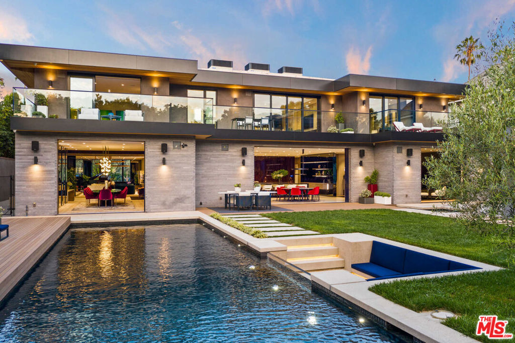 Brought to you by celebrity developers, Meir Siboni and Jonathan Menlo, history has been made with this bold contemporary-style masterpiece sited on one of Hancock Park's most coveted streets. Behind hedges and double gates, this private tennis court estate is a testament to modern luxury, completed in 2021. Conceived from first-class materials, refined finishes and one-of-kind details, this extraordinary home has been built with a quality of craftsmanship and taste that beautifully combine, to stir all the senses. The main residence and separate guest house comprise impeccable living space and include 6 ensuite bedrooms, a personal salon, movie theatre, gym, office, and one-bedroom guest house. Beyond the stately front door, Malerba chandeliers grace a dramatic foyer opening to an expansive living room, marble-clad wet-bar, and dining room complete with a temperature-controlled glass wine cellar. A custom Scavolini kitchen with dual islands and lacquered wood accent wall are the heart of this lavish home and is complemented with a stainless steel, high-end chef's prep kitchen. Above the floating glass, staircase awaits an elegant primary suite that features two large Poliform walk-in closets, a black-marble encased shower with fireplace, soaking tub, and a spacious private balcony. The oversized backyard boasts a sparkling pool with a see-through glass wall providing an underwater view from the adjacent sunken seating area and firepit, regulation tennis court, outdoor kitchen, dining al fresco, impressive motor court, and a large guest home congruent with the taste level and finish of the main estate, are some of the many features of this Crestron smart home. A once-in-a-lifetime opportunity to own the most exquisite estate to ever hit the market in Hancock Park.