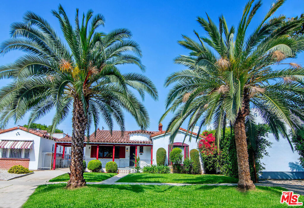 Discover this meticulously preserved 1920s Spanish-style single-story home, boasting 5 bedrooms and 3.5 bathrooms, complemented by a modern ADU. Step onto the welcoming front porch, adorned with fresh Spanish tile and lush greenery, leading to a grand foyer with original parquet flooring and natural wood built-ins. The expansive living room features a wood-burning fireplace and a large picture window, while the formal dining room, with elegant wood wainscoting, overlooks the porch. The charming breakfast nook showcases a built-in China display cupboard, flowing into a spacious kitchen with original hardwood cabinetry, vintage hardware, and striking 1920s deco tile. Three bedrooms feature en-suite bathrooms, with two others sharing well-appointed hallway baths. A versatile office/study and ample hallway storage add functionality. The separate laundry room, doubling as a pantry, opens to a private backyard with fruit trees, synthetic turf, and a luxurious new 2-bedroom, 1-bath ADU. Nestled in the vibrant, tree-lined neighborhood of Beverly Grove this home offers proximity to cultural landmarks, trendy dining, and excellent schools.