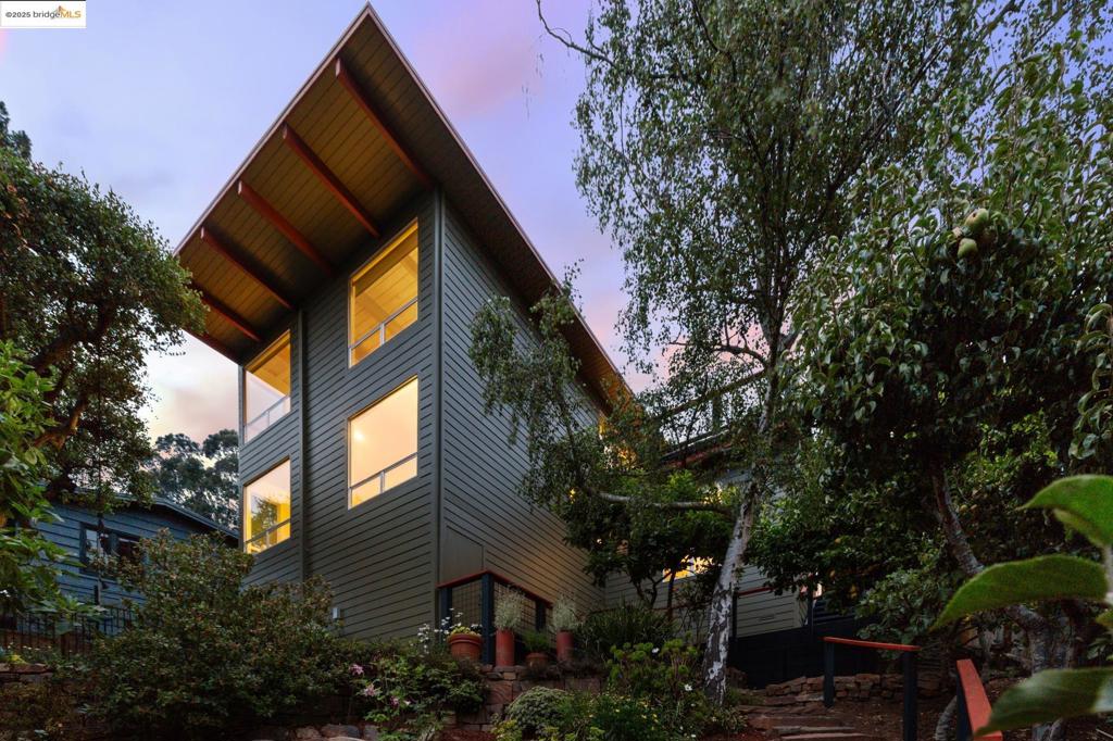 Stunning mid-century home with sweeping Bay and SF views. Open floor plan with floor-to-ceiling glass doors leading to a huge deck for seamless indoor-outdoor living. Features 3 bedroom suites, including a main-level primary with hot tub, outdoor shower, and tropical garden. Lower-level primary with luxury bath and views, plus separate suite with kitchenette and private entrance—ideal for guests or renters. Modern upgrades include solar, heat pump + A/C, and new siding. Double garage with workshop, large driveway, and terraced gardens on a quiet North Berkeley Hills street.