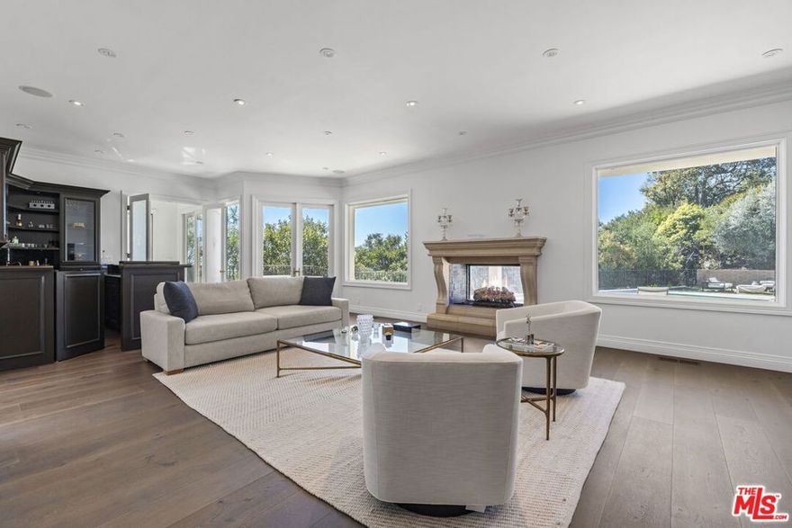 THE 12TH MONTH IS FREE!! Welcome to this stunning 5-bedroom, 6-bath Mid-Century home located in Beverly Hills' coveted Trousdale Estates. Set on nearly half an acre of flat land, this home epitomizes the quintessential Trousdale layout, with expansive walls of glass offering unobstructed views of the oversized pool and sparkling canyon lights. As you pull up the long driveway, you'll feel as though you've entered a world far from the hustle of LA. Upon entering the foyer, you're immediately drawn into the grand living room, which features a statement fireplace, a sunken bar, and an adjacent formal dining room. The doors open seamlessly to the expansive outdoor patio, which boasts various seating areas, an outdoor dining area, and a cozy fireplace perfect for entertaining or relaxing. The large pool is ideal for a leisurely afternoon dip or a few laps, while beyond the pool, the spacious backyard invites you to sit back, relax, and take in the serene surroundings. The master suite anchors the home, offering a walk-in closet and a luxurious en-suite bathroom with a soaking tub. Three additional bedrooms and a large bonus room complete the sleeping quarters, with the bonus room perfect for a home gym or a play area for the kids. The kitchen is a chef's dream, featuring a beautiful island in the center and high-end appliances that are perfect for hosting and entertaining guests. Initially built in 1969, this home has been meticulously renovated, offering a perfect blend of timeless design and modern amenities. It's versatile layout makes it the ideal home for a wide range of tenants. The house is located in the Beverly Hills school district. The house is available furnished or unfurnished. An additional cost will apply if tenants choose to lease the home with furniture. AS A CONCESSION, THE LANDLORD WILL WAIVE THE LAST MONTH'S RENT WHEN YOU SIGN A 12- MONTH LEASE.
