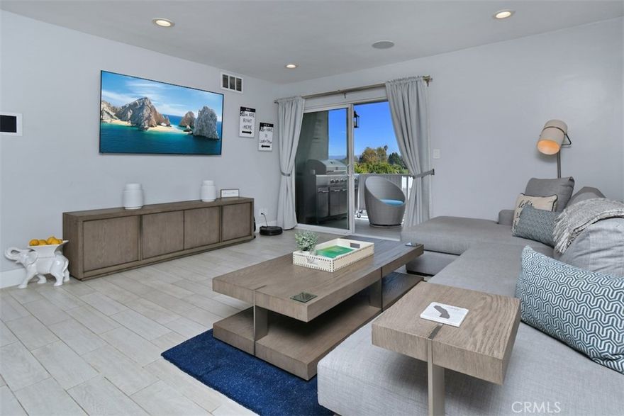 Located in the heart of Sherman Oaks, just one block from Ventura Boulevard, this stunning, modern, top floor condo offers a beautifully upgraded turnkey interior with sweeping views from every window. Tucked away at the back of a small, quiet complex, this smart home spares no expense in design or comfort. Refined with exceptional attention to detail, the open-concept floor plan features a spacious living and dining area adjacent to a chic gourmet kitchen. Highlights include quartz countertops, a glass subway tile backsplash, and premium appliances Viking stove and built-in microwave, Bosch dishwasher, and accent wood paneling. Custom all wood Schuler soft-close cabinetry and a large island with counter seating complete the space. The living room opens to an oversized balcony overlooking the Valley, ideal for relaxing or entertaining. Smart features abound, including recessed lighting on dimmers, a Control4 system with built-in speakers throughout and a Nest thermostat. The designer bathrooms feature imported Mexican concrete tiles, while the primary suite offers a luxurious retreat with dual sinks, a soaking tub beneath a statement light fixture, a heated towel rack, and a spacious walk-in shower. Built-in closets provide ample storage and style. Additional touches include a custom bar with Viking wine fridge, central HVAC, and durable high-end ceramic tile flooring throughout. Perfectly located near Sherman Oaks’ best restaurants, cafés, and boutiques, this sophisticated top-floor condo blends modern luxury with everyday convenience, a truly special place to call home.