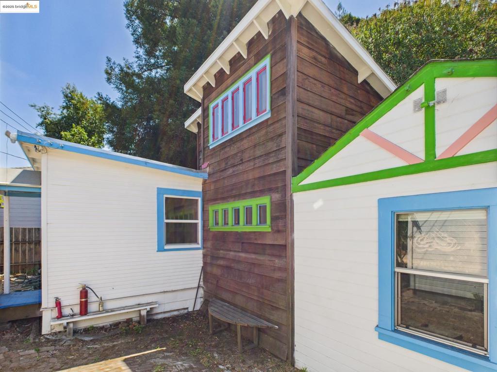 Discover a rare and artistic cottage retreat, thoughtfully designed with beauty in every detail. A large fenced front yard and majestic redwoods set the stage for this unique home. Wood floors, custom tile work, and warm natural light make this home cozy, charming, and comfortable. At the heart of the home, the kitchen shines with new appliances,skylight, and striking Japanese paper cabinet doors. Flexible living spaces abound: a bright sunroom that can serve as dining area, studio, or extra bedroom; a sunny main bedroom with built-in storage; and a second room with loft storage and direct access to the backyard deck. Throughout, lovingly crafted finishes give the home a soulful, creative feel. The private backyard is a haven with a spacious deck, fenced enclosure, and even a charming doghouse for furry companions. A built-in storage bed frame is also available if desired. With its one-of-a-kind character and natural surroundings, this home offers not just a place to live, but a true sanctuary for inspiration.