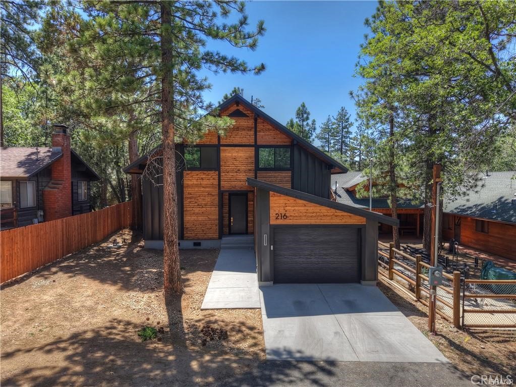 Currently in its final stages of completion, this brand-new modern architectural masterpiece blends sleek design with exceptional functionality—perfectly suited for mountain living, family memories, or a high-performing short-term rental. Featuring a bold double-slope roof, darker-themed exterior, and an expansive rear wall of glass, the home offers dramatic curb appeal and seamless indoor-outdoor connection. Inside, you'll find a bright, airy interior with an open-concept floor plan, soaring ceilings, and oversized doors throughout, creating a sense of space and luxury. With four spacious bedrooms and three full baths, this home comfortably accommodates both relaxation and entertaining. Set on a fire-defendable lot, this home was built with resilience in mind—metal roof and siding, concrete driveway, walkway, patio, and a raised foundation not only provide peace of mind, but also help keep the home warm in winter and cool in summer. Comfort meets innovation with two hidden heating units—one tucked beneath the home, the other in the attic—providing silent, vibration-free convection heat that rises naturally from the floors. A hot water return system circulates warm water every 15 minutes, ensuring near-instant hot water in colder weather. And for modern convenience, the garage includes an EV charger outlet, ready for electric vehicles. Located just 10–15 minutes from everything Big Bear has to offer—lakes, slopes, trails, and town—this property offers a rare opportunity to own a beautifully built, forward-thinking home in the heart of Southern California’s favorite mountain getaway.