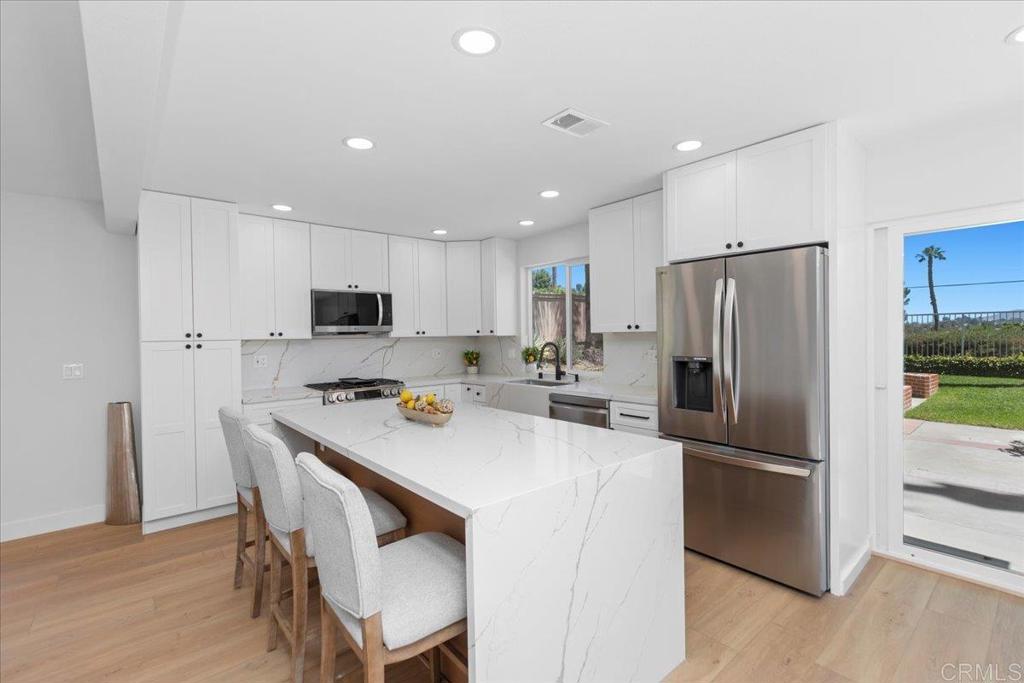 Enjoy the cool breeze and views in this remodeled 3 bedroom + loft home in a desirable gated community in Vista. This open concept home is filled with natural light with vaulted ceilings and designer finishes. The main level offers a living room with fireplace, dining area, and an upgraded kitchen with waterfall island that looks out to the backyard and open space. A convenient half bath completes the downstairs floor plan. Upstairs, a flexible loft adds space for a home office, media area, or playroom. The large primary suite includes a beautifully updated ensuite bathroom, while two additional bedrooms share a stylishly renovated hall bathroom. Take advantage of the gated neighborhood, a community pool, and a prime location near shopping, dining, schools, and commuter routes.