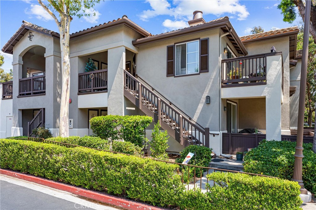 Welcome to this exquisite two-bedroom upstairs, end-unit in the highly desirable Rancho Veracruz community of Tustin Ranch, complete with a 2-car garage! This unit is located in one of the preferred peaceful areas of the community, away from outside traffic or noise. Step into a light-filled living space, where custom painted walls and crisp finishes set a sophisticated tone. The spacious living room is flooded with natural light, enhanced by chic shutters, a cozy gas fireplace, and a sliding glass door that opens to your private balcony—a perfect retreat for morning coffee. Entertaining is effortless in the charming dining room, where vaulted ceilings and a stylish chandelier create a warm ambiance that flows seamlessly into both the kitchen and living room. The kitchen features a long breakfast bar, ample cabinetry, and modern recessed lighting. Across the hall, you'll find a convenient laundry closet with side-by-side washer and dryer hookups tucked behind classic shuttered doors. Both bedrooms are luxurious suites, each with its own walk-in closet and private bathroom—ideal for hosting guests or creating a dedicated office space. The primary suite is a serene escape, featuring a ceiling fan, a roomy en-suite bathroom with ample countertops, elegant cabinetry, accent lighting, and a large tub/shower combo with a sliding glass door. The secondary suite also boasts vaulted ceilings, a walk-in closet, and its own full bathroom with another tub/shower combo. Step out to your sizable outdoor balcony, offering plenty of room for seating and a BBQ setup. Living in Rancho Veracruz means enjoying resort-style amenities, including two sparkling pools, a well-equipped gym, a clubhouse, and easy access to nearby hiking trails, with Peters Canyon Park just a stone’s throw away. Nestled next to the Tustin Ranch golf course, this community also offers convenient freeway access and is minutes from a wealth of shopping, dining, and entertainment options. This home is not just a residence; it’s a lifestyle. Don’t miss the chance to experience Rancho Veracruz living at its finest!