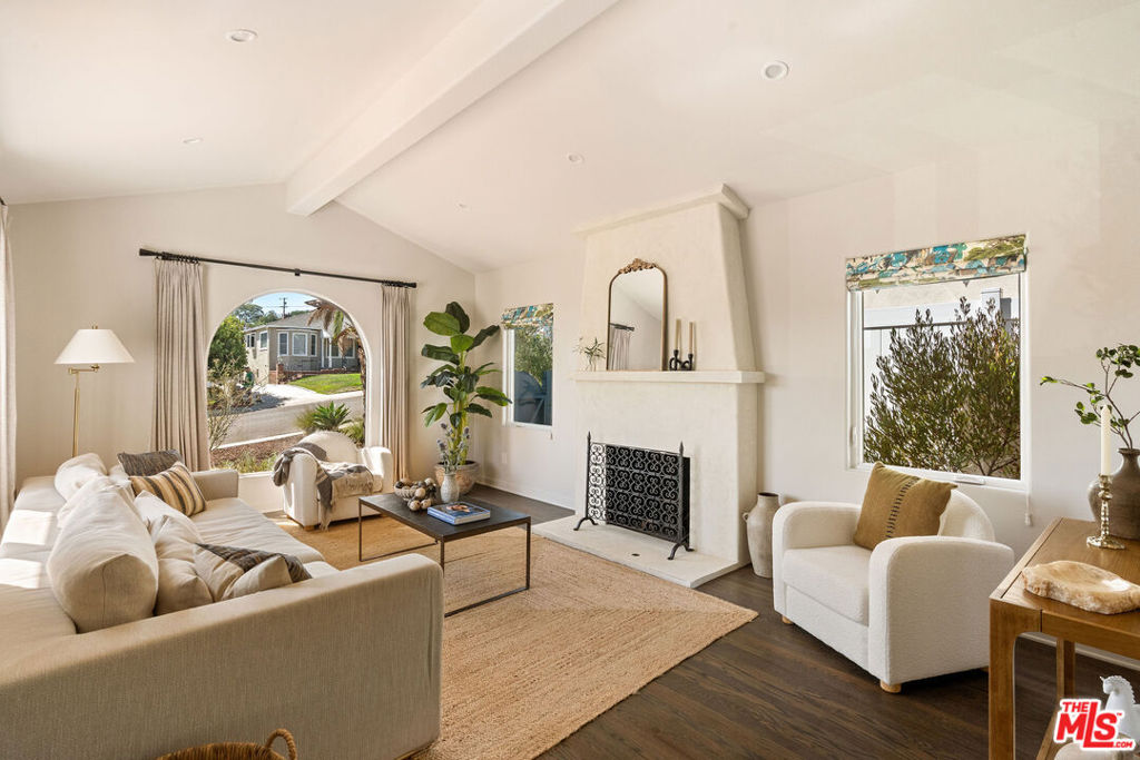 This Spanish-style Westchester residence was taken down to the studs and fully reimagined by a seasoned interior designer, completed in 2022 with impeccable attention to detail. Every space blends modern luxury with timeless character, a decorative fireplace, custom ironwork railings and hardwood floors. The chef's kitchen is a showpiece, featuring custom wood cabinetry with Rejuvenation hardware, Arabescato marble counters, and top-tier European appliances including an ILVE 40" range, brass pot filler, and Fulgor Milano built-ins. The spa-like primary suite boasts a double vanity with Arabescato marble, a freestanding soaking tub, and an oversized shower with Kallista rain fixtures. Designer window treatments and curated finishes throughout underscore the home's elevated design. Outside, drought-tolerant landscaping, automatic lighting, and citrus and fruit trees create a private backyard retreat. A finished garage with 200v EV charging outlet completes this turnkey offering. Ideally located on a quiet, welcoming street, just minutes from Playa del Rey, Playa Vista, Silicon Beach, and LAX, this home delivers a rare blend of coastal convenience, Spanish character, and true designer pedigree.