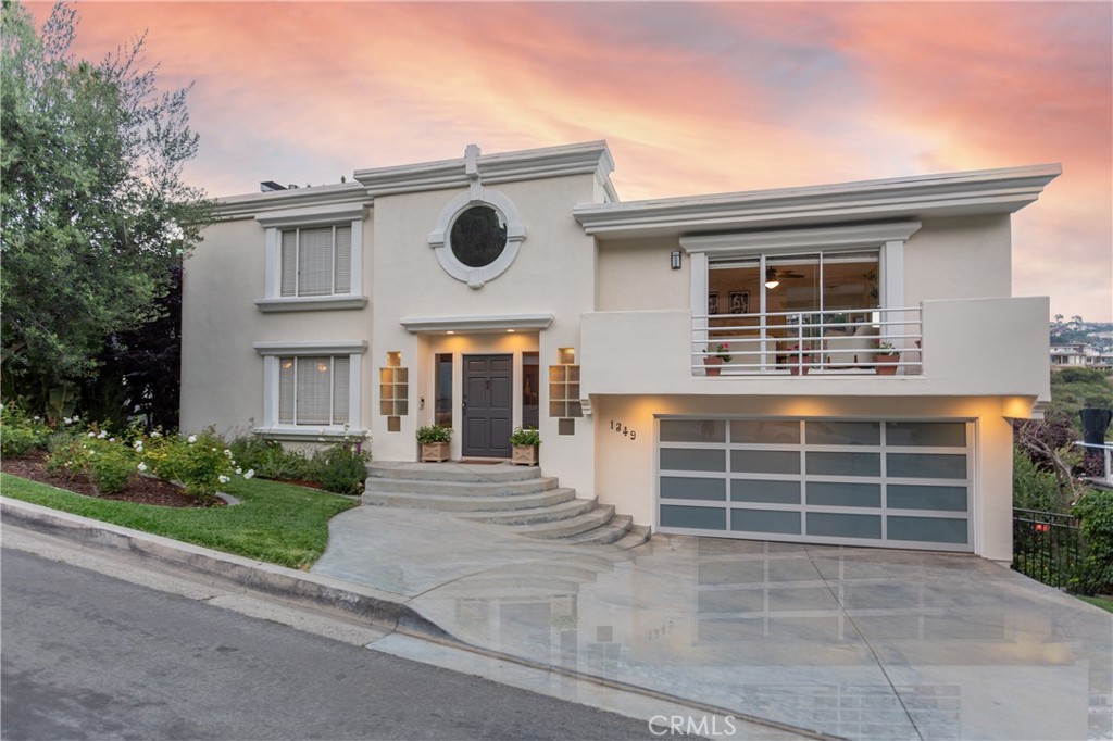 Welcome to 1349 Cerritos Dr—a beautifully positioned home tucked into the hills of Laguna Beach, offering scenic views, thoughtful design & a flexible layout that fits a variety of lifestyles. Located on a quiet cul-de-sac with no through traffic, you'll appreciate the peaceful setting just high enough above the village to avoid parking woes & congestion that come with living in a vacation destination. This 4-bed, 3.5-bath home spans 3,116 sq ft on a 7,070 sq ft lot. A unique curved entry & oversized circular window create a striking first impression. A spacious 2-car garage with direct access adds convenience & storage. Inside, natural light floods the open living spaces. Natural stone, marble & wood floors create a relaxed yet refined atmosphere. The layout is both open & functional, with distinct areas for gathering & retreat. Thanks to its elevated location & ocean-close setting, the home enjoys refreshing coastal breezes year-round—keeping the interior cool & comfortable. The kitchen is well-equipped with stainless appliances, wraparound granite counters & ample storage. Large picture windows invite the outdoors in, while the adjacent dining area opens to a generous balcony—perfect for morning coffee or sunset dinners. Upstairs, bedrooms are generously sized & full of natural light. The primary suite feels light-filled & private, with serene views. Bathrooms feature dual vanities, neutral finishes & solid storage. A lower-level bonus room offers flexibility—ideal for a guest suite, home office, or family room. Step outside to a private backyard retreat—tiered, landscaped, & framed by mature avocado trees. Multiple areas invite entertaining, relaxing or simply enjoying the setting. After the beach, rinse off in the outdoor shower. Families will love the ease of living, with a school bus stop on Cerritos Dr. In summer, enjoy live music drifting in from nearby Bluebird Park. All this just minutes from Laguna’s iconic beaches, hiking trails, shops & restaurants. Prefer not to walk? The City offers a free, on-demand, shared-ride service—Laguna Local—connecting residential neighborhoods & major activity hubs. 1349 Cerritos Dr blends space, setting & lifestyle in one of Southern California’s most treasured coastal communities.