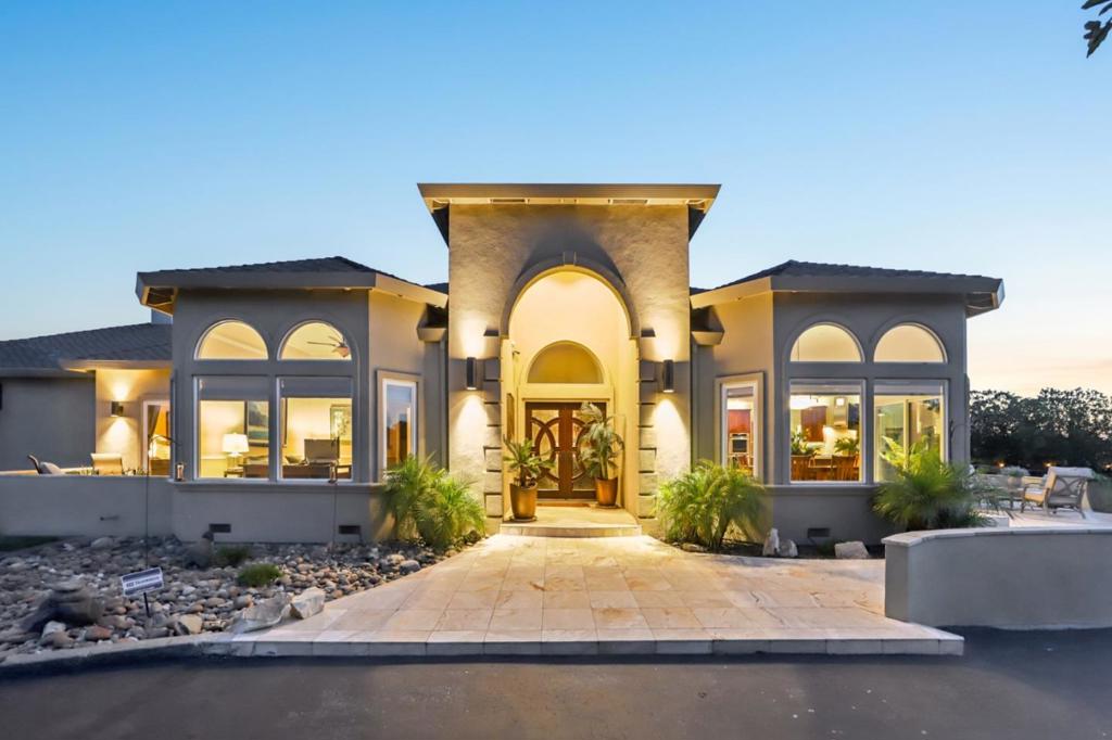 Welcome to 2600 Geneil Ct a hilltop estate on 5.2 acres with panoramic views of Hollister and San Juan Oaks Golf Club. This single-level home features a chefs kitchen with premium Thermador appliances, quartz countertops, a walk-in pantry, and stylish slide-out shelving. The spacious living room is built for entertaining with a custom bar, two beverage fridges, and a gas fireplace. The luxurious primary suite includes a two-way fireplace with quartz counters and a large walk-in shower. The expansive outdoor living area offers a pergola with a ceiling fan, gas heaters, and remote sunshades perfect for enjoying stunning sunsets. The property includes a converted barn ADU (2 bed, 2 bath, kitchenette) and a separate studio, ideal for guests, multi-generational living, or rental income. Enjoy modern conveniences like drip irrigation, ceiling fans throughout, and in-wall HVAC. A rare opportunity to own a versatile and private retreat.