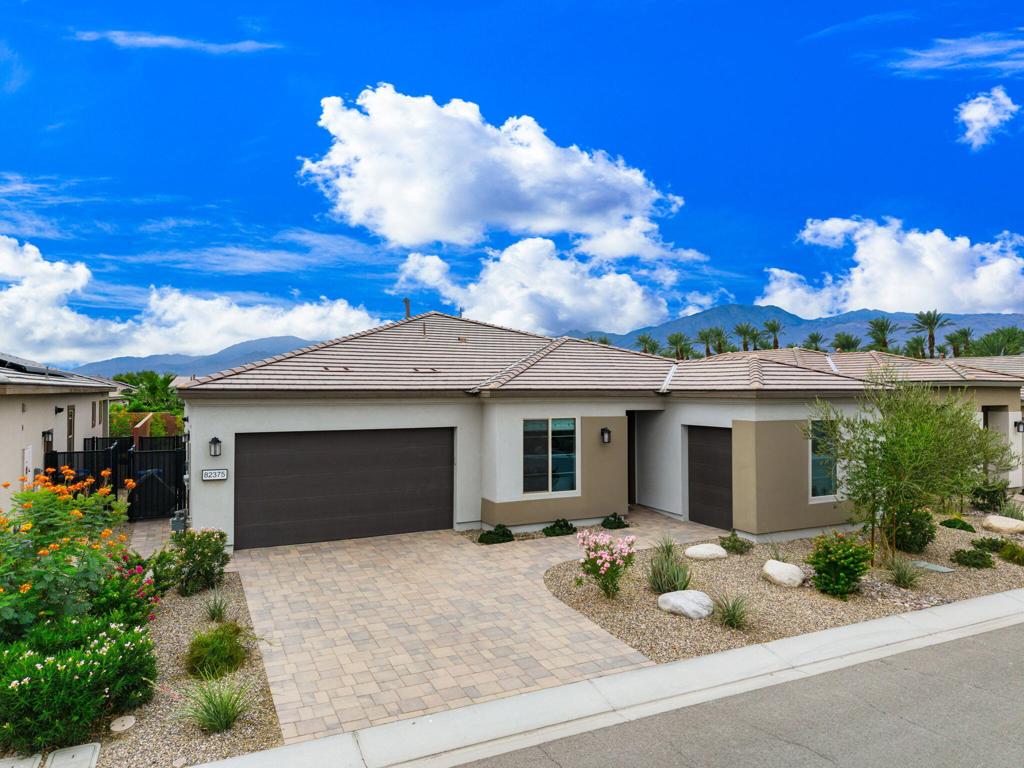 Experience resort-style living at its finest in the gated 55+ community of Trilogy Polo Club with this highly upgraded Proclaim model showcasing 3 bedrooms plus den/office, 2.5 baths, and approximately 2,141 sq. ft. of beautifully designed living space. This residence features an open-concept floor plan filled with natural light, seamlessly blending indoor and outdoor living through expansive sliders that open to a covered paver patio, perfect for entertaining or relaxing against the backdrop of the Santa Rosa Mountains. The chef's kitchen is a true showpiece with upgraded cabinetry, quartz countertops, stainless steel appliances, and an oversized island with seating, flowing effortlessly into the great room and dining area. The primary suite offers a spa-like retreat with a granite dual-sink vanity, chic tiled shower, and spacious walk-in closet, while two guest bedrooms share a stylish bath. Additional highlights include a powder room, golf cart garage, laundry room with a sink, luxury vinyl plank flooring, ceiling fans, custom California closets in the bedrooms and garage, solar, and numerous upgrades throughout. Residents of Trilogy Polo Club enjoy an exceptional array of amenities, including a modern clubhouse with a restaurant, fitness center, resort and lap pools, tennis, pickleball, golf simulator, poker/billiards room, culinary and art studios--all designed to elevate the desert lifestyle.