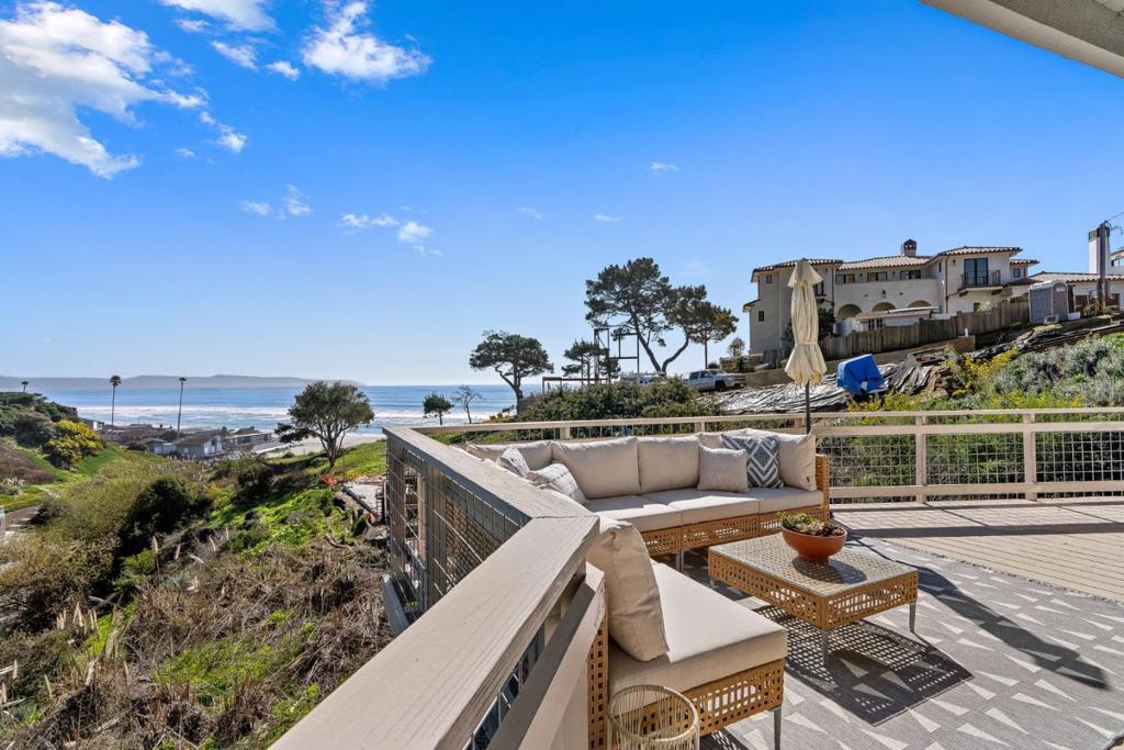 Enjoy the best of the Rio Del Mar lifestyle in this fabulous 5 bedroom, 3 bath home. Built in 1965, but recently updated throughout, including designer light fixtures, new door hardware, fresh paint, hardwood floors, and new, high-end carpet. This beach house is being offered with the empty view lot next door! The main floor has a beautiful kitchen, a separate dining area with an chic chandelier, and the views from the living room are fabulous. There is also an ocean-view bedroom with an en-suite bathroom, and access to the deck. The deck is perfect for watching the waves, BBQing, or relaxing in the sun. The middle floor has three bedrooms (two with views of the waves) and a big bathroom. All of the bathrooms are nice; they were redone in 2014 and have had only light use since then. The bottom floor has another bedroom, laundry with side-by-side appliances, and another bathroom. The bedroom has views of the beach and ocean and has an exterior door. It would make an ideal office, too! The gate in the back yard opens up to a path to Hidden Beach. You can be on the sand in minutes. All this AND the vacant lot next door: 5,401sq ft to build on, or keep as a buffer. Or expand the house! HOUSE and TWO PARCELS are included in sale APN 043-131-13 (with house) and APN 043-131-14.