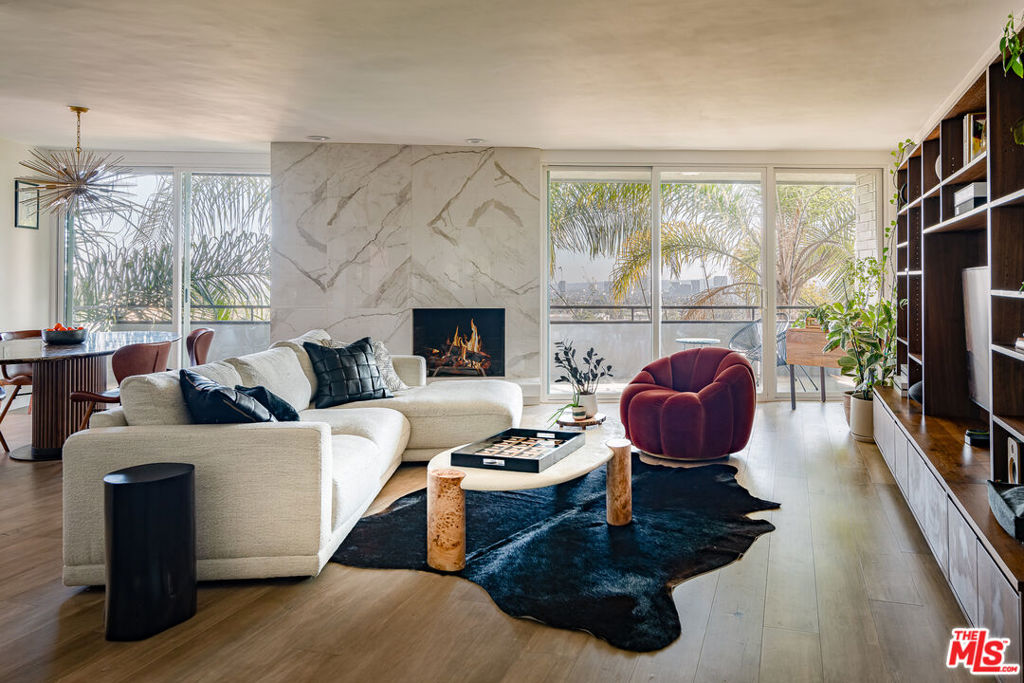Single-story 2 bedroom 2 bath condo with panoramic views in prime West Hollywood. Newly renovated open floor plan living with floor to ceiling sliders, hardwood floors and large private balcony. Stone clad fireplace anchors the living room which floods with natural light. Custom kitchen has quartz countertops and stainless steel appliances. Large separate dining space flows effortlessly to the outdoors. Built in bar with a wine fridge doubles as the perfect coffee station. Incredible primary suite with custom walk-in closet system and resort like primary bath. Second bedroom is outfitted as an office with a convertible sleeper sofa to accommodate any guest. South facing unit in a Mid-Century architectural boutique building. 2 parking spaces included. Adjacent to the Residences at the Pendry, steps from the Sunset Strip with easy access to LA's best dining, entertainment and nightlife.