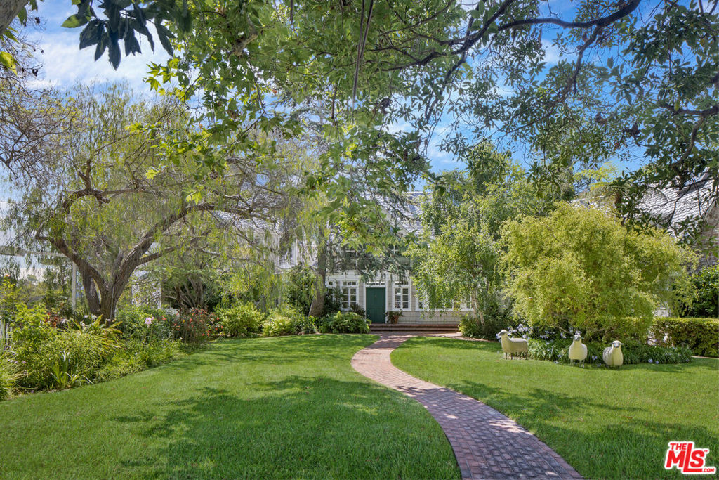 Sited on over one acre of land surrounded by towering eucalyptus trees and rolling lawns, 694 Amalfi is an incomparable, gated and private estate on the most coveted street in the Riviera. Designed by famed architecture firm Morgan, Walls & Clements (The Wiltern, El Capitan Theatre, Adamson House) in 1933 for film director and writer Oliver H.P. Garrett, the home is a perfect blend of old Hollywood grandeur and modern-day sophistication. A meandering brick pathway winds its way through park-like grounds and up to the home's dramatic front entryway foyer with double-height wood-beamed ceiling. Through the foyer is the heart of home -- a vast and voluminous, natural light-filled great room replete with soaring gambrel ceiling, a grand brick fireplace, dining and living room areas and access through French doors to the backyard. Off the great room are the chef's kitchen with breakfast nook, and the sophisticated bar room with exposed beam ceiling and its own fireplace. The first floor of the home features a comfortable den, a bedroom that can also serve as an office and the generous primary suite with coffered ceiling, elegant fireplace, walk-in closet, separate his and hers bathrooms and tree and canyon views. Upstairs, there are three bedrooms including a spacious second primary suite with vaulted ceiling, fireplace, walk-in closet and spa-like bathroom. On the other side of the house there is a bedroom and additional bedroom/exercise room with wood-beamed ceilings and tree views. On the lower level of the home is a bar room off the tennis court for postgame drinks, or a game of pool. The expansive backyard features a sparkling pool, multiple seating and entertaining areas, bath and views of the Riviera Country Club and canyon. A once-in-a-lifetime estate in one of the most prestigious neighborhoods in Los Angeles.