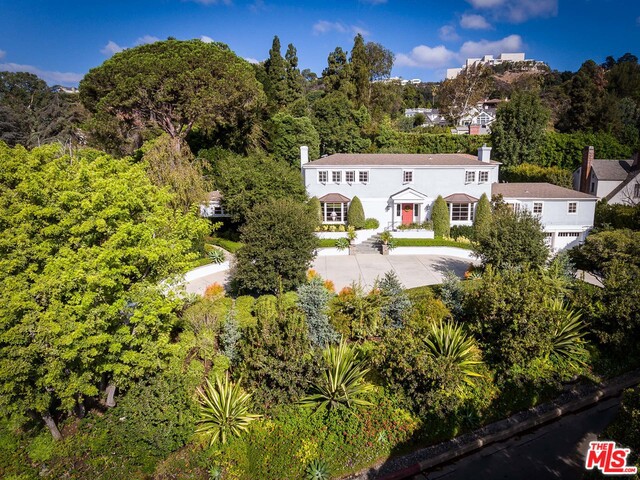 Ideally sited on a beautifully landscaped 28,997 sq. ft. property, with peek-a-boo views of the city, this East Coast traditional home effortlessly exudes a contemporary California lifestyle within the gated neighborhood of Brentwood Circle. Wide openings and expansive windows facilitate easy flow as you transition from room to room in this 5,668 sq. ft. residence, complete with a spacious guesthouse and three-car garage. Inspiring architectural details, like the rounded sitting room embraced by wall-to-wall windows, are experienced throughout the home's interiors. Once outside, the property's resort-style amenities set the stage for hosting outdoor fetes, poolside respites and fire pit gatherings. Joining the expansive outdoor kitchen with BBQ is a covered dining terrace that leads to the lovely pool grounds, spa and manicured lawn. While secluded from the city, the home is only moments away from the shops and restaurants of Brentwood Village.