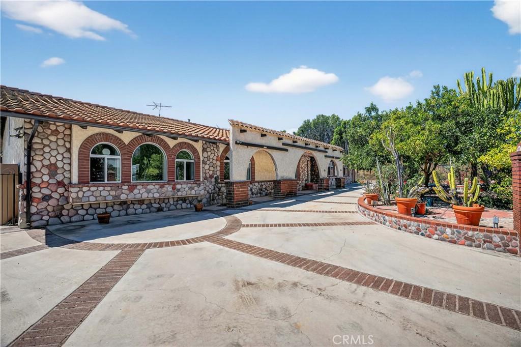 Welcome to “Old Granada Hills,” a neighborhood celebrated for its large parcels, orange orchards, and timeless charm. This is your golden opportunity to create a true family compound.
Set behind gates, this expansive 3,000+ sq. ft. home rests on a flat 18,700 sq. ft. lot with an impressive 110 feet of street frontage. A gracious circular driveway leads you inside where you’ll find 5 bedrooms and 4 bathrooms, including a massive primary suite with a wall of closets and spa tub.
The Chef’s kitchen is outfitted with a Viking oven, Wolf range, wood cabinetry, and abundant counter space. Multiple living and entertaining areas include a spacious living room, formal dining room, and an enormous bonus/game room—all enhanced by soaring wood ceilings, granite flooring, and oversized dual-pane windows. The cozy family room, complete with a wood-burning stone fireplace, opens to the covered patio and sparkling pool. Every bathroom is luxuriously finished in granite from top to bottom.
And the pool—OMG! Unlike most residential pools, this one is fully tiled from edge to floor. Black-tile swim lanes line the bottom, perfect for training or competition. After swimming, relax in the tiled spa or lounge on the shaded covered patio.
Beyond the pool lies a lighted tennis court, ideal for tennis, basketball, or even pickleball. The property also offers space for an RV, potential ADU, and a three-car garage with central I-beam—a dream setup for any craftsman or mechanic.
With the 405, 5, and 118 freeways, CSUN, Trader Joe’s, and Porter Ranch shopping and dining just minutes away, the location couldn’t be more convenient.
Yes, the home could use some TLC—fresh paint, new carpet in a few bedrooms, and light updates would make it shine again. But replicating these incredible improvements today would cost a fortune. After more than 60 years in the same family, this special property is ready for its next chapter.
Offered As-Is by the seller’s trust. What you see is what you get—the chance to build sweat equity and own a one-of-a-kind Granada Hills estate.
