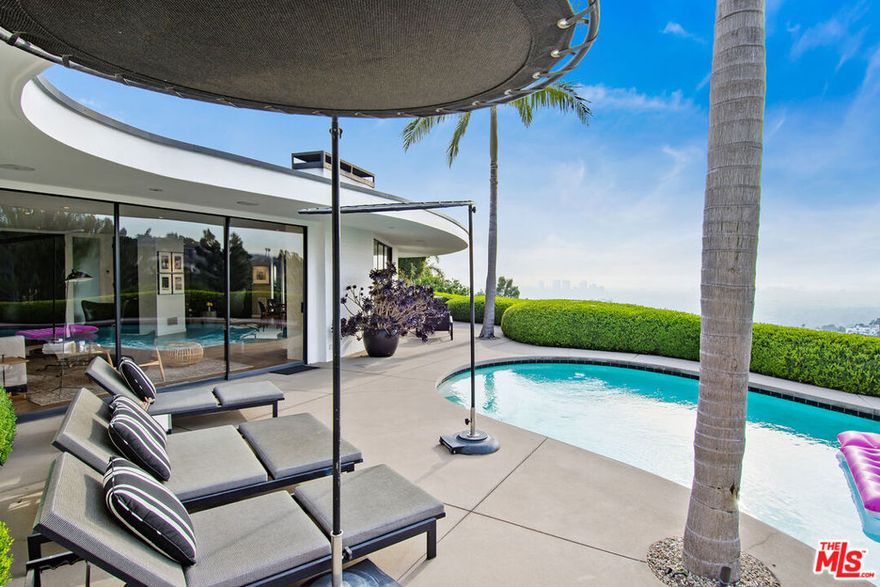 Welcome home to your oasis in the hills. This extraordinary mid-century modern home was designed by Robert Earl AIA to make the best use of its spectacular views from almost every room. Perched above the Sunset Strip on one of the most desirable sections of the Bird Streets, this private home is situated at the end of a cul-de-sac and is perfect for entertaining. The home features 3 bedrooms, 3.5 baths within 2,616 square feet and offers views from downtown to the sea. The property's substantial public spaces merge indoor and outdoor living seamlessly, with gorgeous walls of glass that open out to the well proportioned pool in the back. You will find an opulent primary suite with walk in closet, and sumptuous bath with views of city. The home also features wood floors throughout, private gated entry, a gorgeous gourmet kitchen and includes 2 additional bedrooms, 2 more  baths, and a powder room. Best of all there is off street parking that can fit up to 4 cars. A true lux gem in the Hollywood Hills waits for you.