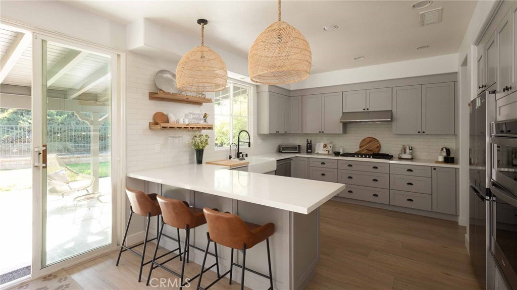 This beautifully updated home offers a flexible open floorplan and an expanded kitchen, perfect for modern living. Every detail has been thoughtfully renovated in recent years—no expense spared.
Step inside to find newer water-resistant LVP wood-like flooring throughout and a spacious great room concept, where the wall separating the formal living and family room has been removed to create a large, open entertaining space. A custom-finished fireplace anchors the room, which flows seamlessly into the kitchen and backyard featuring a large, covered patio.
The kitchen has been completely remodeled with soft-close cabinetry, smart storage solutions, newer appliances, and a designer porcelain faux brick backsplash. The Scandinavian-inspired downstairs bathroom boasts a floating vanity, walk-in shower with seating, and a frameless glass door. Also on the main level are a guest bedroom, an expanded coat closet and a three-car garage.
Upstairs, the expansive primary suite offers a cozy sitting area, spa-like bathroom with a dual vanity, large shower, and jetted freestanding soaker tub, plus a spacious walk-in closet. Three additional bedrooms and a fully renovated guest bathroom complete the upper level.
Located on a quiet cul-de-sac within a gated private community of luxury homes, residents enjoy access to resort-style amenities including a clubhouse, two Olympic-sized swimming pools, tennis courts, sports courts and proximity to award-winning schools (Oak Hills Elementary, Rancho Pico Junior High, and West Ranch High School). Centrally located minutes from freeway, shopping and restaurants.
