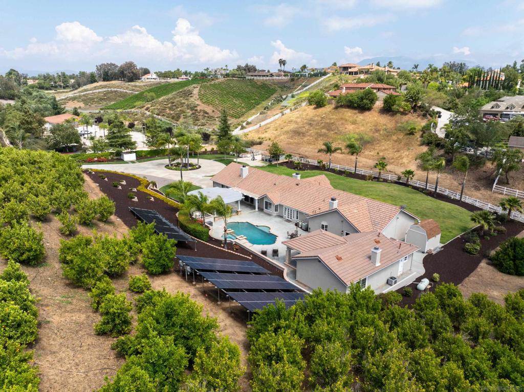 Nestled in the heart of town, this gated 3.75-acre property offers the rare feeling of your own private slice of countryside—without sacrificing convenience or access to city amenities. The whole property is self-watering for your ease & on agriculture-zoned water (water bills during the worst months are only $300-400/mo). Beautifully remodeled, the 3,800 sq. ft. main residence blends luxury, comfort, and self-sustaining living with 4 spacious bedrooms, an office, and formal living and dining rooms. At the heart of the home is a show-stopping chef’s kitchen with new Thermador appliances and an oversized custom island. Step outside into your own private resort with a heated pool and spa, covered outdoor living room with fireplace, and expansive grounds ideal for year-round entertaining. The detached 800± sq. ft. pool/guest house features a full bathroom and Sub-Zero 200-bottle wine fridge—perfect for overnight guests, game nights, or a private studio. Designed for sustainability, the fully solar-powered (solar is fully owned) estate includes agriculture-zoned water (water bills during the worst months are only $300-400/mo), a self-watering garden, fruit trees, and a producing mandarin grove (~375 trees yielding ~$3,500/year, with potential for $10,000+ at full maturity). The custom chicken coop has a real shingle roof, 16-gauge wire buried 3 ft. deep, plus power and water for year-round functionality. Bonus: Enjoy front-row views of Temecula’s 4th of July fireworks. Minutes from top schools, shopping, and wineries—this is luxury country living in the heart of Temecula.