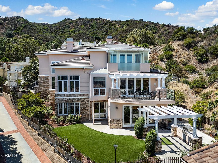Perched high in the hills above Glendale, this custom-built 1998 residence showcases sweeping views of the lower basin and sparkling city lights. Designed with scale and sophistication, the home offers 5 bedrooms, 5 bathrooms, and two kitchens, along with an array of refined living and entertaining spaces.Spanning three levels, the floor plan blends intimacy with grandeur. Highlights include a wood-paneled library with wall-to-wall bookcases and dramatic views, a formal dining room, and a welcoming family room with a broad balcony overlooking the city. The living room is accented with Venetian plaster walls and an artist-designed stained-glass depiction of Springtime above the entry door, creating a striking first impression.At the heart of the home, the main kitchen features an oversized granite island, custom-designed cabinetry, and state-of-the-art appliances, including a Sub-Zero refrigerator/freezer, Wolf range/oven, and Bosch dishwasher. An additional kitchen offers versatility for entertaining or multigenerational living.The oversized primary suite enjoys its own view balcony and a luxurious bath with separate tub and shower. On the lower floor, an ensuite bedroom and versatile entertainment room open seamlessly to the gardens, offering an ideal indoor-outdoor flow.Outdoors, the grounds are designed for year-round enjoyment with lush landscaping, a covered patio, built-in BBQ, and tranquil gardens. A newly paved driveway enhances the home's curb appeal, while a solar power system provides modern efficiency.Inside, the extensive use of marble, granite, wood, and glass creates a timeless sense of opulence--equal parts warm and dramatic. Sited at the end of a cul-de-sac, this property offers both privacy and prestige.This is more than a home--it is a statement of elegance and comfort, perfectly suited for intimate living or large-scale entertaining, all set against a backdrop of panoramic vistas.