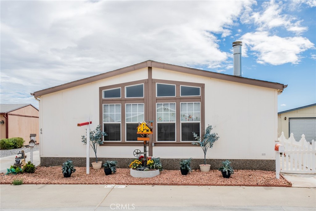 Welcome to 22241 Nisqually Rd #66, located in the highly desirable Vista Del Rosa, a premier 55+ gated community in Apple Valley. The park is professional managed with excellent onsite management. This spacious and beautifully designed home is the perfect blend of comfort, convenience, and style—ideal for those looking for a serene, active lifestyle in a welcoming environment. As you drive up the long driveway and approach the front door, you’ll be greeted by the inviting charm of this beautiful home. Once inside, you’ll appreciate the wide hallway and open floor plan, which provides ease of mobility and a sense of spaciousness. Large windows throughout fill the home with natural light, creating a warm and airy atmosphere. The stunning wood-look floors add a touch of elegance and complement the home’s design. The dining area flows into the kitchen, creating an ideal space for entertaining family and friends. The kitchen is a chef’s dream with a large island providing extra counter space, stainless steel sink, gas stove with built-in microwave, and a walk-in pantry for ample storage. A skylight above adds a touch of natural light. The split bedroom design offers privacy for both residents and guests. The spacious primary bedroom features an en-suite bathroom with a soaking tub, step-in shower, linen closet, reach-in closet, and a bidet toilet for added comfort and convenience. The oversized family room is a true highlight, boasting more large windows that bring in the light and a cozy fireplace perfect for relaxing evenings. Ceiling fans further enhance the room’s warmth and charm, making it a wonderful space for gathering with loved ones. This family room can also be used as a home office, craft room or fifth bedroom. Vista Del Rosa is a pet friendly, well maintained park and offers fantastic amenities for an active lifestyle, including a sparkling pool, soothing Jacuzzi, lighted tennis courts, dog park, clubhouse with kitchen, billiard room, and craft room. There are plenty of social activities to enjoy too. Close to shopping, dining, and local attractions. Whether you’re relaxing at home or enjoying all the wonderful amenities, this is a place where you’ll feel right at home. Don’t miss out on the opportunity to make this beautiful home yours—schedule a private tour today and experience the lifestyle and community at Vista Del Rosa!