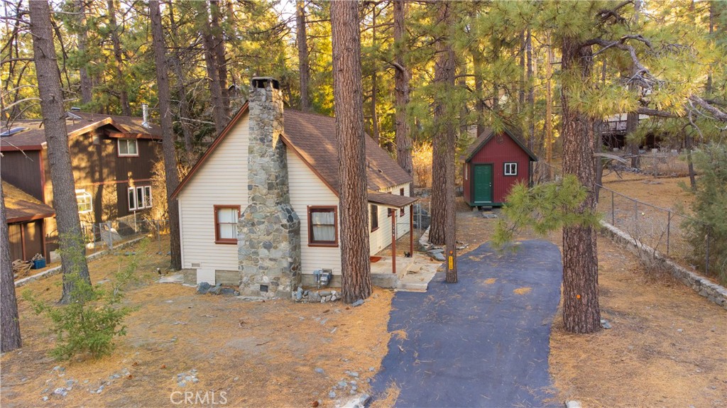 Charming Vintage Cabin with Modern Updates & Cozy Character! This one-of-a-kind, solidly built cabin is bursting with vintage charm and timeless appeal! Nestled among towering pine trees, this move-in ready retreat offers the perfect blend of rustic warmth and modern convenience. Step inside to a beautiful great room featuring soaring knotty pine ceilings, tongue & groove detailing, and a stunning stone fireplace—ideal for keeping you warm and cozy during the colder seasons. The primary bedroom is conveniently located on the main floor, while a spacious loft-style second bedroom offers additional sleeping space upstairs. A versatile laundry room doubles as a bonus sleeping area with built-in bunk beds, perfect for the little ones or extra guests. Outside, a detached storage shed provides plenty of space for tools and gear, while the large lot offers ample parking for friends and family.
With a new roof and water heater (both installed in 2020), this cabin is ready for new owners to enjoy right away. Experience the beauty of nature in this clean, inviting, and truly special home—don't miss your chance to make it yours!