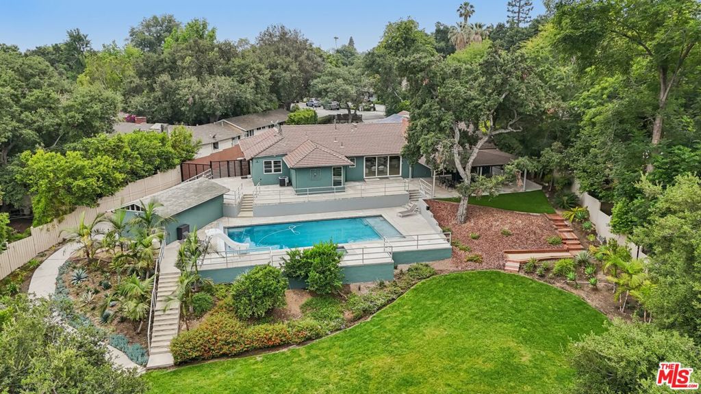 Tucked away at the end of a quiet cul-de-sac in the coveted Arcadia Unified School District, this 4-bed plus office, 4-full bath single-level home offers lots of square footage of updated living space on a ~30,000 sq ft lot. The flexible floor plan supports multi-gen living with a separate wing featuring its own bedroom and full bath. Interior highlights include recessed lighting, alarm system, engineered hardwood floors, formal dining room, and a remodeled kitchen with quartz countertops, gas cooktop, dual electric ovens, island seating, 2 wine refrigerators, full ice maker, and walk-in pantry. The home is wired with Cat5 and prepped for surround sound. Exterior features include a saltwater pool and spa with micro-pebble finish, covered patio, large fenced backyard, leased solar with battery backup, dual EV charging, and a finished garage. Updated plumbing, newer windows, central HVAC, RV hookups and a tankless water heater add to the home's desirability. How would you use the large back yard and pool?