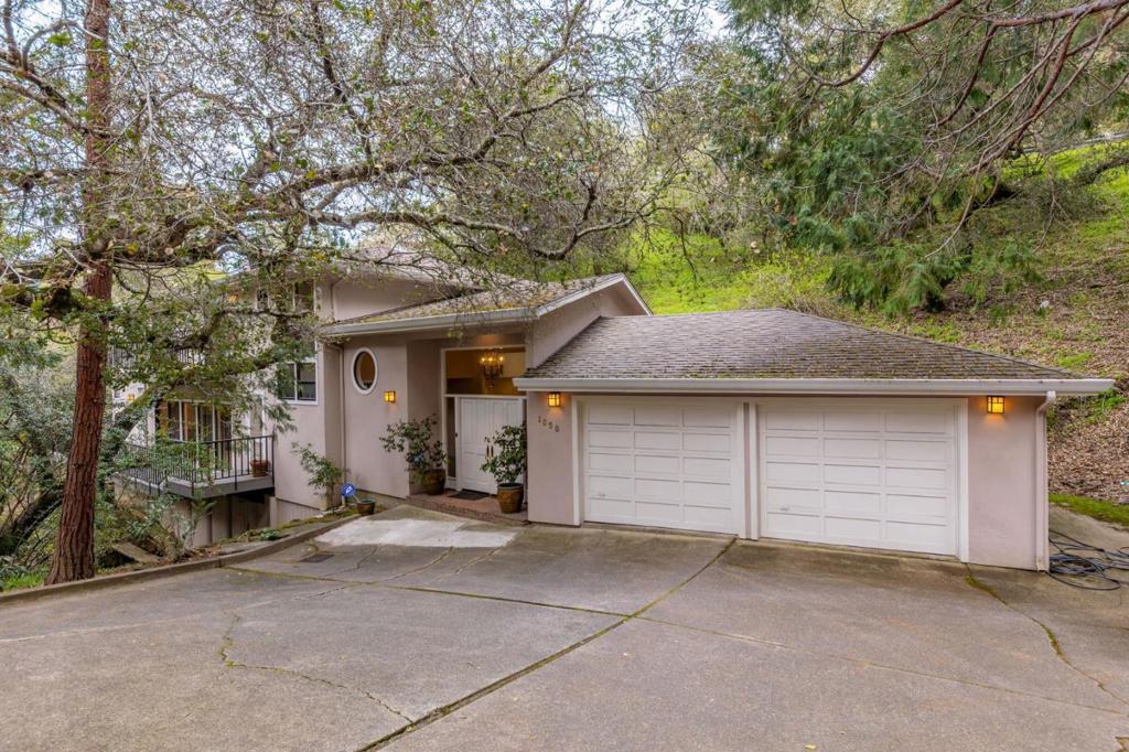 Nestled down a long driveway in the prestigious Hillsborough Knolls neighborhood, this enchanting home offers a serene retreat surrounded by majestic trees, complemented by the soothing sounds of Cherry Canyon Creek. The property is conveniently located just over a mile from the 280 Freeway and a short drive from Downtown San Mateo and Downtown Burlingame. The residence also has access to top-rated schools. Entering through elegant double doors, the sun-drenched foyer welcomes you with recessed lighting and hardwood flooring that flows throughout the home. The airy formal living room features floor-to-ceiling windows, a sliding door, and a striking fireplace. The chef's kitchen, is complete with high-end appliances including 2 Sub-Zero refrigerators, a Wolf stovetop, Thermador double wall ovens, & a Miele dishwasher. A butler's pantry with custom cabinetry and a wine cooler enhances entertaining options. Upstairs, the luxurious primary suite boasts a high tray ceiling, a private balcony, and a spa-like bathroom. Two additional bedrooms share a balcony, one with an en-suite bathroom. Completing the upper level is another bathroom and a convenient laundry room. Blending privacy, luxury, and convenience, 1050 Hayne Road offers an exceptional lifestyle opportunity in Hillsborough.