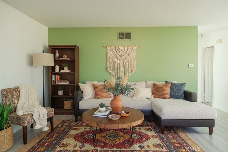 Thoughtfully updated upper-level 2-bedroom, 1-bath condominium offering 873 square feet of light-filled living space with a stylish California boho-inspired design. The upgraded kitchen features butcher block countertops, floating open shelving, and a functional layout ideal for everyday living and entertaining. The recently renovated bathroom includes a modern vanity, updated flooring, and contemporary finishes.
 Dual-pane windows installed in 2020 improve energy efficiency, climate control, and noise reduction throughout the home. With only one shared wall and no neighbors above or below, this unit provides a rare level of privacy within the community.
Step outside to a spacious private balcony, perfect for relaxing or dining al fresco. Parking is a standout feature, with two parking spaces, including one assigned space (13D) and a highly desirable private one-car garage equipped with a remote-controlled automatic door. Fresh interior paint and touch-ups are currently in progress. Residents enjoy access to resort-style community amenities, including a pool and spa. Photos include both vacant and virtually staged images of the living and dining areas to showcase potential layouts and furnishing options.

Photographs include both vacant and virtually staged representations of the living and dining areas to illustrate potential layout and furnishing options.