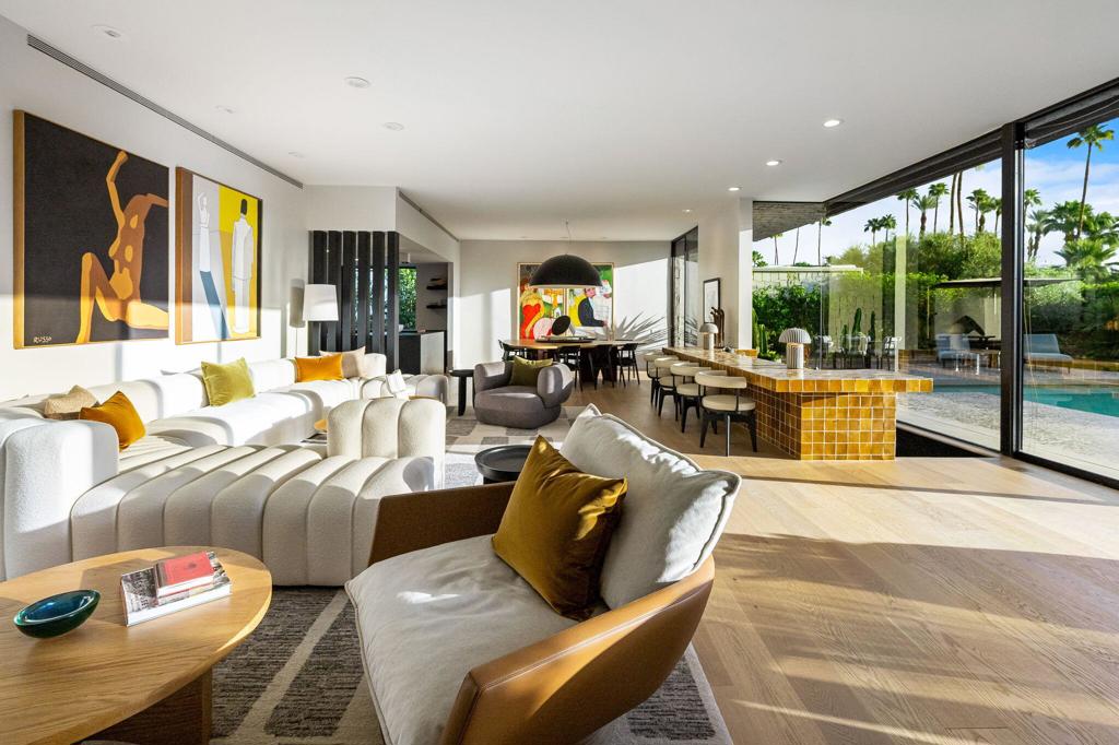 Sophisticated style, high-end appointments and an enviable sense of privacy define this newly reimagined and upgraded Rancho Mirage home. Now the preeminent residence at Tamarisk West, the detached single-level design was taken down to the studs and rebuilt as a modern showplace that is equally adept at accommodating grand entertaining and relaxed daily living. Illuminated by a skylight, the foyer introduces a free-flowing floorplan of approximately 2,958 square feet that presents two ensuite bedrooms, two- and one-half baths, and a retreat-caliber library with custom built-ins and private bath. Floor-to-ceiling windows and sliders create a wall of glass in the living room, where a step-down wet bar features a stylish countertop and built-in Sub-Zero beverage refrigerator. The dining room is impressively sized and opens to both the backyard and a new custom kitchen. Pro and novice chefs alike will appreciate an island with raised butcher-block prep center, a walk-in pantry, black wood cabinetry, large garden window, Caesarstone countertops, and top-tier appliances including a built-in cabinet-matched Sub-Zero refrigerator. Guests will appreciate the comforts of a large secondary bedroom with skylight, built-in desk, walk-in closet and private bath, and homeowners can escape to an elegantly modern primary suite. Enjoy two open walk-in closets with custom built-ins, and a seamless bath with freestanding tub, two sinks, quartz countertop, and a dual-head shower with slider to the backyard. Air conditioning and epoxy flooring enhance the attached two-car garage, and a brand-new custom laundry room boasts a sink and ample cabinetry. Owned solar helps power the home, which reveals interiors by Seattle-based Lucas, an award-winning design studio. Custom details include wide-plank white oak flooring, high ceilings, mitered corner windows in select locations, wood slat wall treatments, designer lighting and wallpaper, and preferred plumbing fixtures and hardware. All new plumbing and electrical systems ensure years of efficiency and convenience. Backing to the Tamarisk Country Club golf course, grounds are enriched with a new pool and spa, new large-format tile decking, a built-in BBQ station and modern landscape lighting. Mountain views embrace the home, which is located on fee land with no lease and close to hiking trails, golf, and fashionable dining and shopping destinations throughout Rancho Mirage, Palm Springs and Palm Desert.