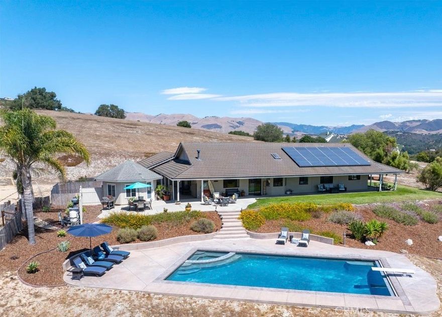 Welcome to 225 Pioneer Circle -An inspiring place to call home where serene luxury meets endless panoramic beauty on 5.7 acres set in the heart of Arroyo Grande’s rolling hills. Here, every sunrise paints the horizon, every evening invites al-fresco dining, and every detail speaks to refined California living. This single-level residence spans 2,878 square feet of thoughtfully curated design. Expansive windows frame endless views while open living and formal dining rooms with cathedral ceilings, built-in custom cabinetry and a stunning floor-to-ceiling fireplace, flow seamlessly into a chef’s kitchen with attached dining room anchored by an impressive cook-top island -perfect for amazing meals and special gatherings with family and friends. The primary suite is a retreat within a retreat—complete with a spa-inspired bathroom with double vanity and separate private water closet, a spacious walk-in closet with ample storage, and two separate, versatile spaces that offer the possibility of a home office or craft area, as well as a large lounge room ideal for peaceful quiet relaxation -the endless options for these spaces are open for you to tailor to your life and your vision. Two additional generous-sized bedrooms with attached baths are situated with privacy in mind, offering space, comfort and convenience for family members and visiting guests alike. Outdoors the estate transforms into your own private playground complete with an approximately 250 square foot casita/pool house, a sparkling heated swimming pool with diving board and automatic cover, several large patio areas for relaxation and entertaining under star-lit skies, and an enclosed beach volleyball court -a perfect spot to enjoy time with family and friends. The oversized driveway offers several options for RV or boat parking, and the three-car garage—complete with its own half bath—make every outdoor gathering effortless. This amazing home's amenities also include a large indoor laundry room with built-in storage, an integrated Tesla charging station, two solar systems for both home and pool electrical needs, and plenty of room to expand with a guest house or ADU. This estate is more than a home—it’s truly a place to realize the life you've dreamed of. Just moments from the quaint Village of Arroyo Grande, the gorgeous vineyards of Edna Valley, and the charm of San Luis Obispo this is the opportunity you've been looking for -a prime serene location and luxury Central Coast living at its finest.