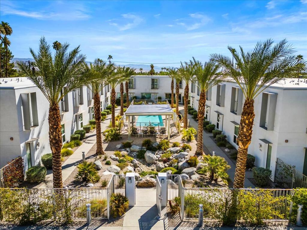 Welcome to unit 303 at Palm 2150, where contemporary Bauhaus elegance meets true Palm Springs living. This stunning 3-bed, 3-bath townhome spans approximately 1,440 sq ft of refined indoor/outdoor space -- perfectly suited for full-time living, a stylish getaway, or an income-producing property.Step inside to an open-concept layout where the kitchen, dining, and living areas flow seamlessly under expansive windows and glass doors, bathing the interiors in natural light. Stylish modern floor tiles, linear electric fireplace, sleek quartz countertops, stainless steel appliances, and frameless contemporary cabinetry elevate the space with modern minimalism.The two upstairs bedrooms offer privacy and tranquil mountain-lined views, with the primary suite delivering en suite luxury. Each bath reflects high-end design and function.Outdoor living is a delight here: enjoy your own private patio off the main living area, perfect for entertaining or quiet mornings. As part of the exclusive Palm 2150 community (17 townhomes), this residence also enjoys access to the lush courtyard with palm-lined landscaping, 45-foot pool & spa, lounge areas, and common gardens -- an idyllic backdrop for relaxed living.Centrally located on Zanjero Road, you're minutes from all Palm Springs has to offer -- restaurants, art, culture, desert adventures.Don't miss this rare opportunity to own a state of the art, architecturally inspired townhome that harmonizes modern design, outdoorsy charm, and prime Palm Springs location.