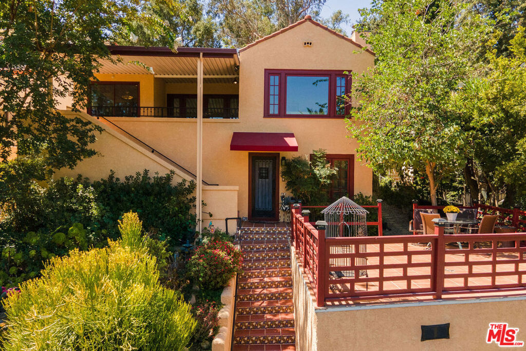 Perched on the sunny shoulders of Adams Hill, this lovely Spanish home glows with charm, its walls washed in warm tones, a lush garden in bloom, and incredible views. Four bedrooms and three baths spill with natural light, as the smell of eucalyptus drifts through the windows, carrying birdsong with it. The living room with its handmade tile fireplace hearth greets you like an old friend. The kitchen with its 1950s diner charm dares you to feel anything but joy as the morning sun creeps across the crape myrtle blossoms while you sip your coffee. Down the hall are the laundry room, two guest bedrooms, and a large primary suite boasting high ceilings, walk-in closet, and a sumptuous spa-like en suite bath. From there sliding doors open out to the backyard as your lot keeps going on up the winding path amongst the trees. Modern updates pepper her rich history, including solar panels, crispy newer HVAC, and updated electrical all make her turn-key ready to welcome her next caretaker. Lastly the knock out is the bonus private guest unit with a separate entrance downstairs, featuring a full en suite bath, and gorgeous backlit bar lending you incredible versatility - perfect for guests staying over, a great work from home set up, or your own little speakeasy for entertaining complete with wine cellar and bar affectionately known as the Sunset Lounge. Just outside the Spanish tile deck above the detached 2 car garage offers itself as a natural host to gatherings large and small where evenings stretch long under the stars. This is Adams Hill, where the world feels small and neighborly, yet the best of Glendale, Atwater, Highland Park & Eagle Rock await: Kafn Cafe, Dune, Little Ripper, Joy, Bub and Grandma's, Dunsmoor, Din Tai Fung & The Americana all just minutes from your door. Welcome home!