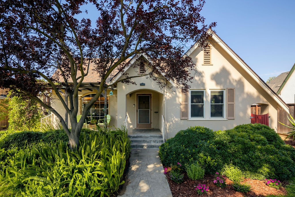 This enchanting Taylor Wheeler, located in Fresno's Tower District, is just around the corner from shops, restaurants, local theater and more. Instantly welcoming, the home boasts concrete steps and pathway to the front patio, a lovely purple leaf plum, and large front grassy area. Upon entry, your eyes are drawn to the distinctive coved ceilings, brick fireplace and arched window looking out to the front garden. Beautiful hardwood floors, arched doorways and wood doors contrast beautifully with the light-filled interior. Just through the entry and living room, you find an elegant dining room adjoining the kitchen and breakfast nook, complete with original built ins and access to the backyard. Adjacent to the kitchen you will find the laundry room, which offers an additional exit to the backyard. The private spaces include the spacious primary bedroom with sliding glass door to the backyard, a second bedroom with closet, a large updated full bath and a third spacious bedroom overlooking the front garden. The rear yard is ready for your personal touch with plenty of shaded space and garden beds ready to create your personal retreat. The long driveway culminates in a detached 2 car garage and includes a shed with potential 1/2 bath (buyer to verify). Additional amenities include energy efficient dual pane widows, 2'' blinds and ample built-in storage. Cherished by the current owners, this property is a wonderful place to call home and is ready for its next chapter.