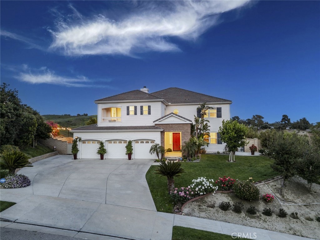 Views, privacy, serenity and space - Built in 2008 and loved by the original owners, 12356 Longacre Avenue is a stunningly updated home located in the prestigious Cagney Ranch Estates of Granada Hills. Offering just under 5,000 square feet of thoughtfully designed living space, this 5-bedroom, 4.5-bath property blends modern luxury with everyday comfort, all framed by sweeping mountain and city views. A grand entrance with soaring ceilings sets the tone, leading into expansive living areas featuring significant designer upgrades. The home features two primary suites, including a convenient first-floor suite with a walk-in closet, and an upstairs primary retreat with a cozy fireplace, private balcony, and a spa-like bathroom featuring a large soaking tub, dual vanities, and a large custom walk-in closet. The chef’s kitchen showcases a large center island, Wolf oven and microwave, Sub-Zero refrigerator, custom cabinetry, and a spacious walk-in pantry. A large upstairs loft offers additional flexible living space, perfect for a media room, home office, or play area. Rich French white oak floors flow throughout, complemented by marble-finished luxury bathrooms, custom closet systems, and curated Restoration Hardware lighting, mirrors, and fixtures. Additional highlights include a large laundry room, custom wrought-iron staircase railings, paid-off solar panels, a 3-car garage with new cabinetry and motors, and an expansive driveway accommodating up to 9 cars. The formal living and dining rooms are crowned with a coffered ceiling, and the home is enhanced by updated LED lighting and custom high-end window treatments. Outdoor spaces are equally refined, featuring mature fruit trees (plum, fig, persimmon, mulberry, loquat), David Austin roses, a tranquil fountain, and built-in speakers for effortless entertaining. Ideally situated near parks, hiking trails, top-rated schools, and major freeways, this exceptional home offers a rare opportunity to live in one of Granada Hills' most desirable communities.