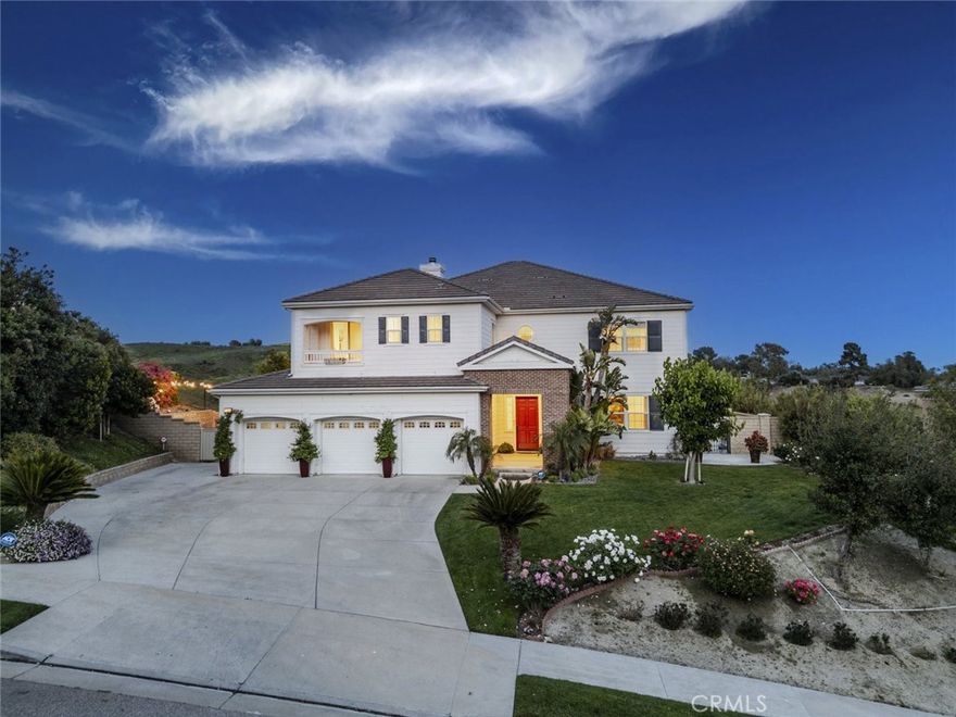 Views, privacy, serenity and space - Built in 2008 and loved by the original owners, 12356 Longacre Avenue is a stunningly updated home located in the prestigious Cagney Ranch Estates of Granada Hills. Offering just under 5,000 square feet of thoughtfully designed living space, this 5-bedroom, 4.5-bath property blends modern luxury with everyday comfort, all framed by sweeping mountain and city views. A grand entrance with soaring ceilings sets the tone, leading into expansive living areas featuring significant designer upgrades. The home features two primary suites, including a convenient first-floor suite with a walk-in closet, and an upstairs primary retreat with a cozy fireplace, private balcony, and a spa-like bathroom featuring a large soaking tub, dual vanities, and a large custom walk-in closet. The chef’s kitchen showcases a large center island, Wolf oven and microwave, Sub-Zero refrigerator, custom cabinetry, and a spacious walk-in pantry. A large upstairs loft offers additional flexible living space, perfect for a media room, home office, or play area. Rich French white oak floors flow throughout, complemented by marble-finished luxury bathrooms, custom closet systems, and curated Restoration Hardware lighting, mirrors, and fixtures. Additional highlights include a large laundry room, custom wrought-iron staircase railings, paid-off solar panels, a 3-car garage with new cabinetry and motors, and an expansive driveway accommodating up to 9 cars. The formal living and dining rooms are crowned with a coffered ceiling, and the home is enhanced by updated LED lighting and custom high-end window treatments. Outdoor spaces are equally refined, featuring mature fruit trees (plum, fig, persimmon, mulberry, loquat), David Austin roses, a tranquil fountain, and built-in speakers for effortless entertaining. Ideally situated near parks, hiking trails, top-rated schools, and major freeways, this exceptional home offers a rare opportunity to live in one of Granada Hills' most desirable communities.